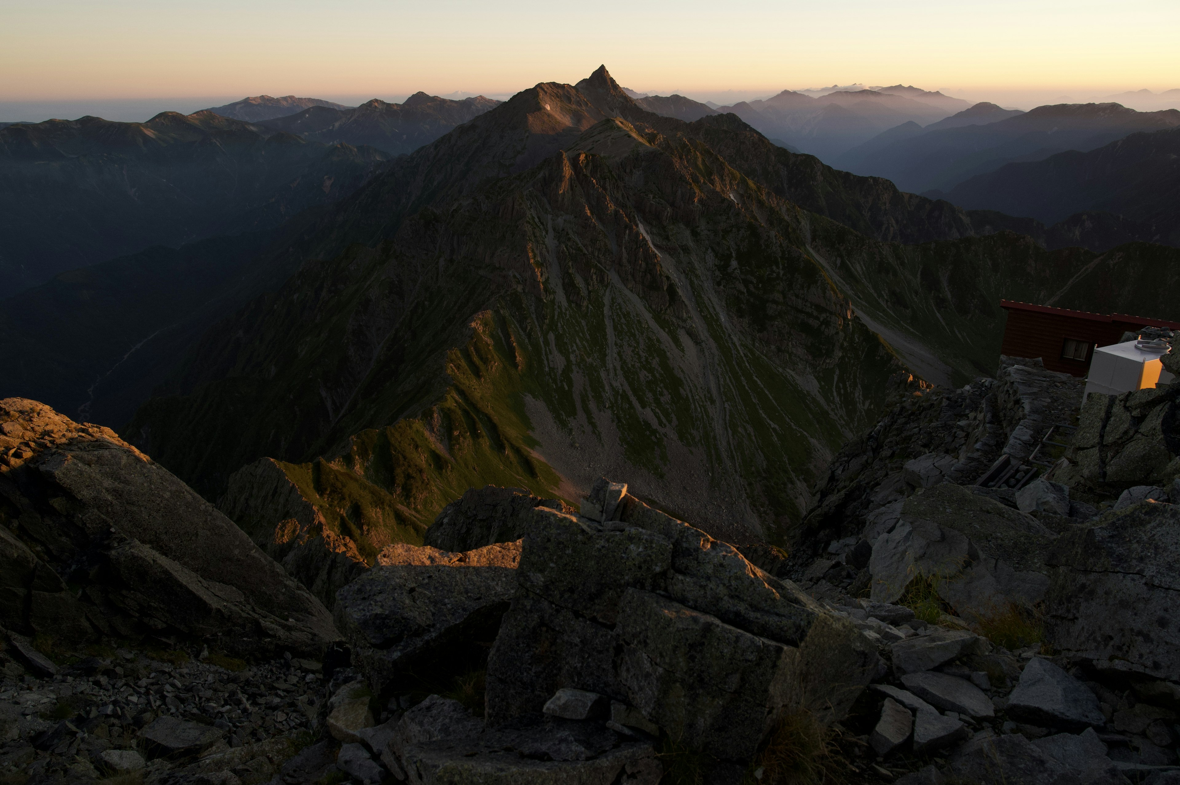 Berggipfel bei Sonnenuntergang mit felsigem Gelände