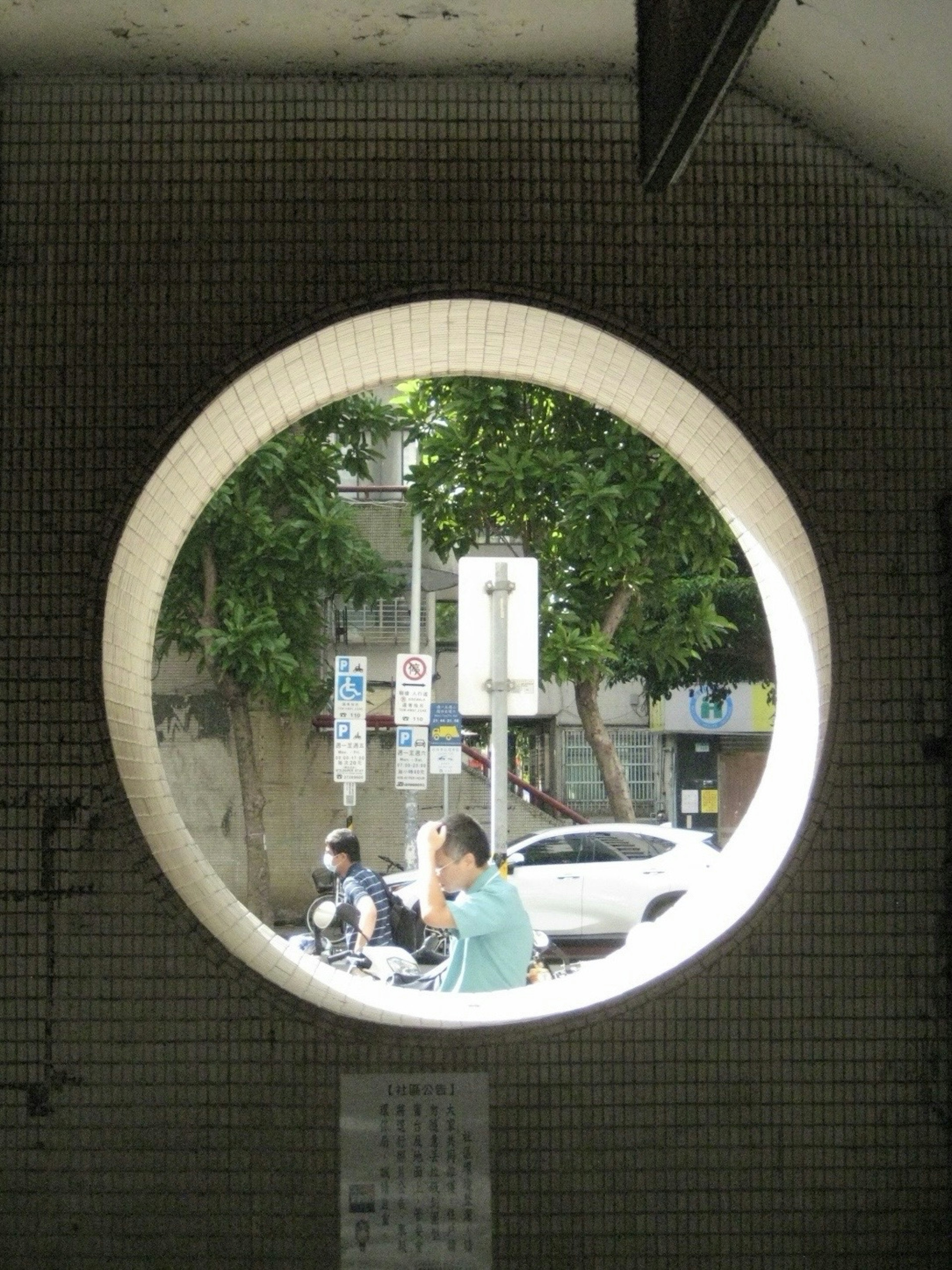 View through a round window showcasing pedestrians and vehicles