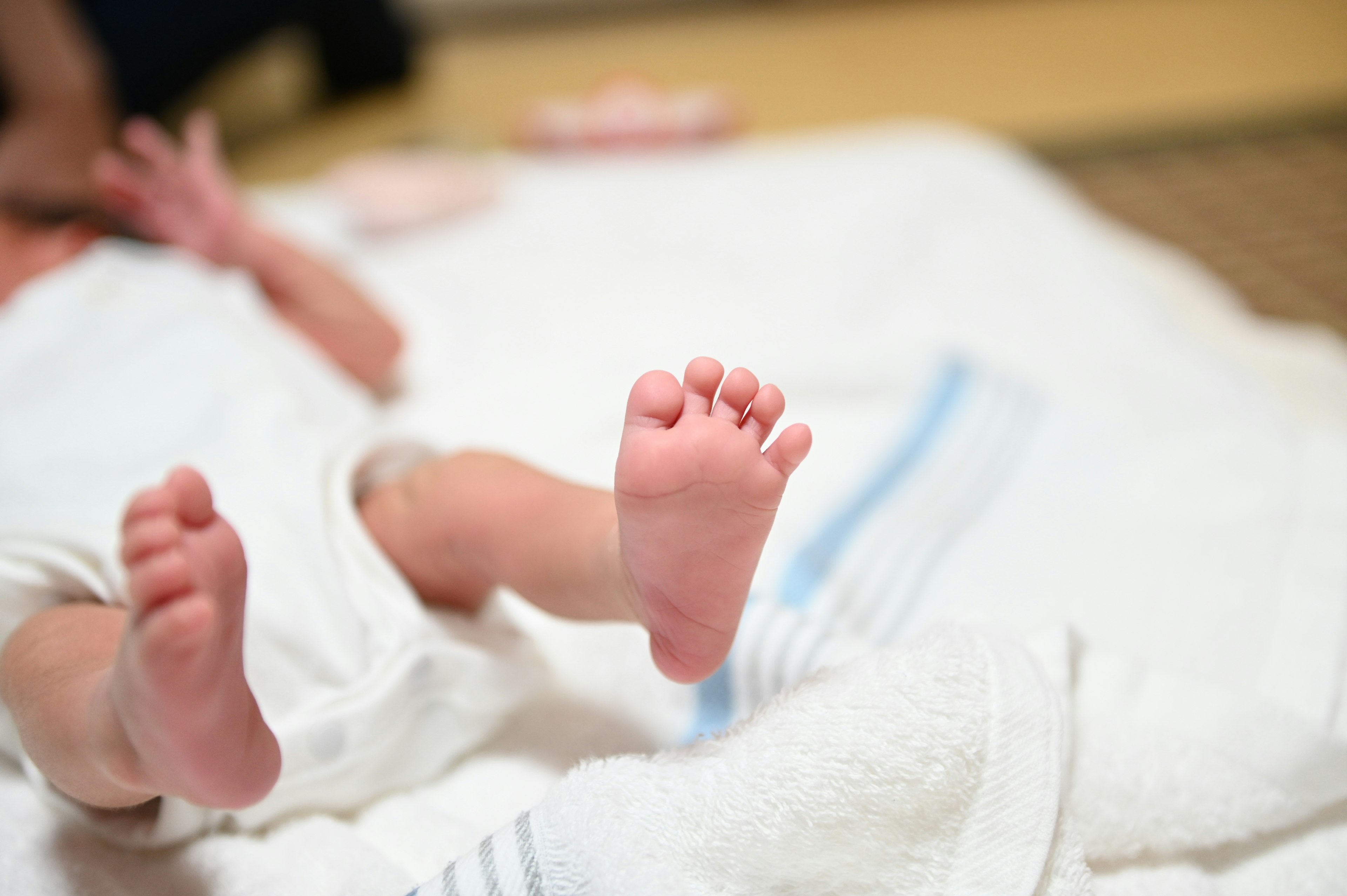 Piedi di un bambino appoggiati su un asciugamano bianco con uno sfondo morbido