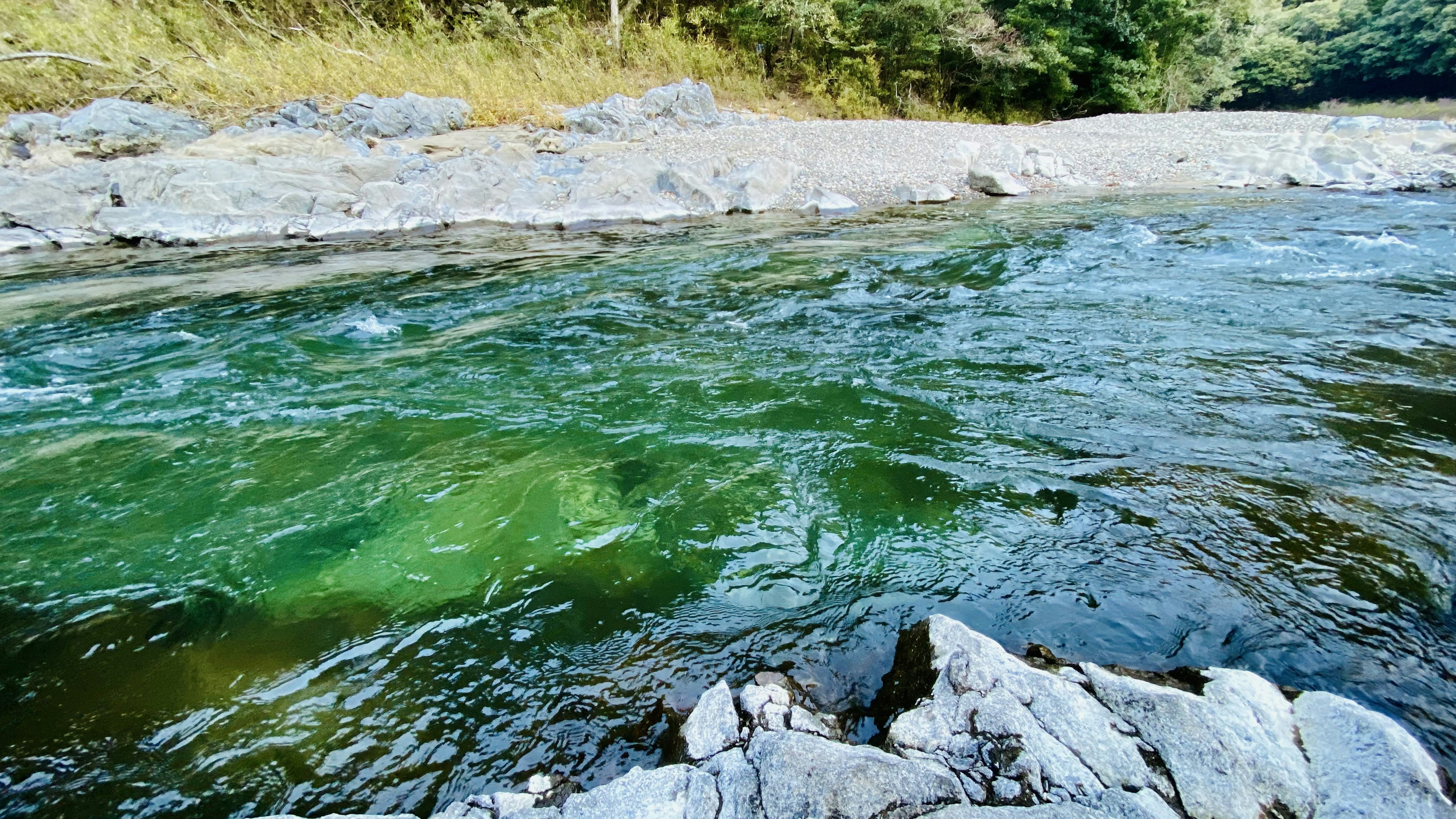 Natürliche Landschaft mit einem fließenden Fluss und Steinen