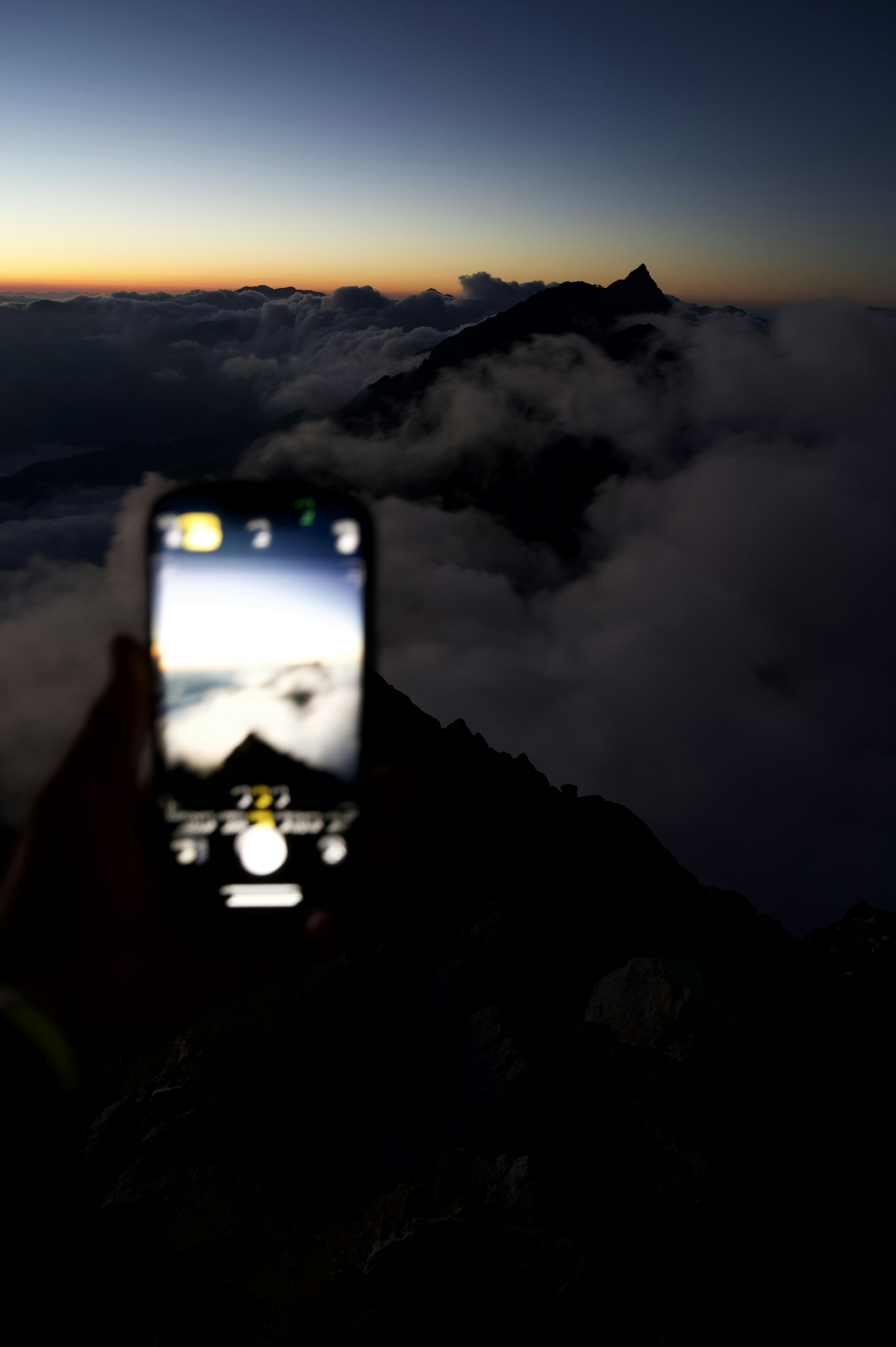 山頂からの夕暮れの景色を撮影したスマートフォン