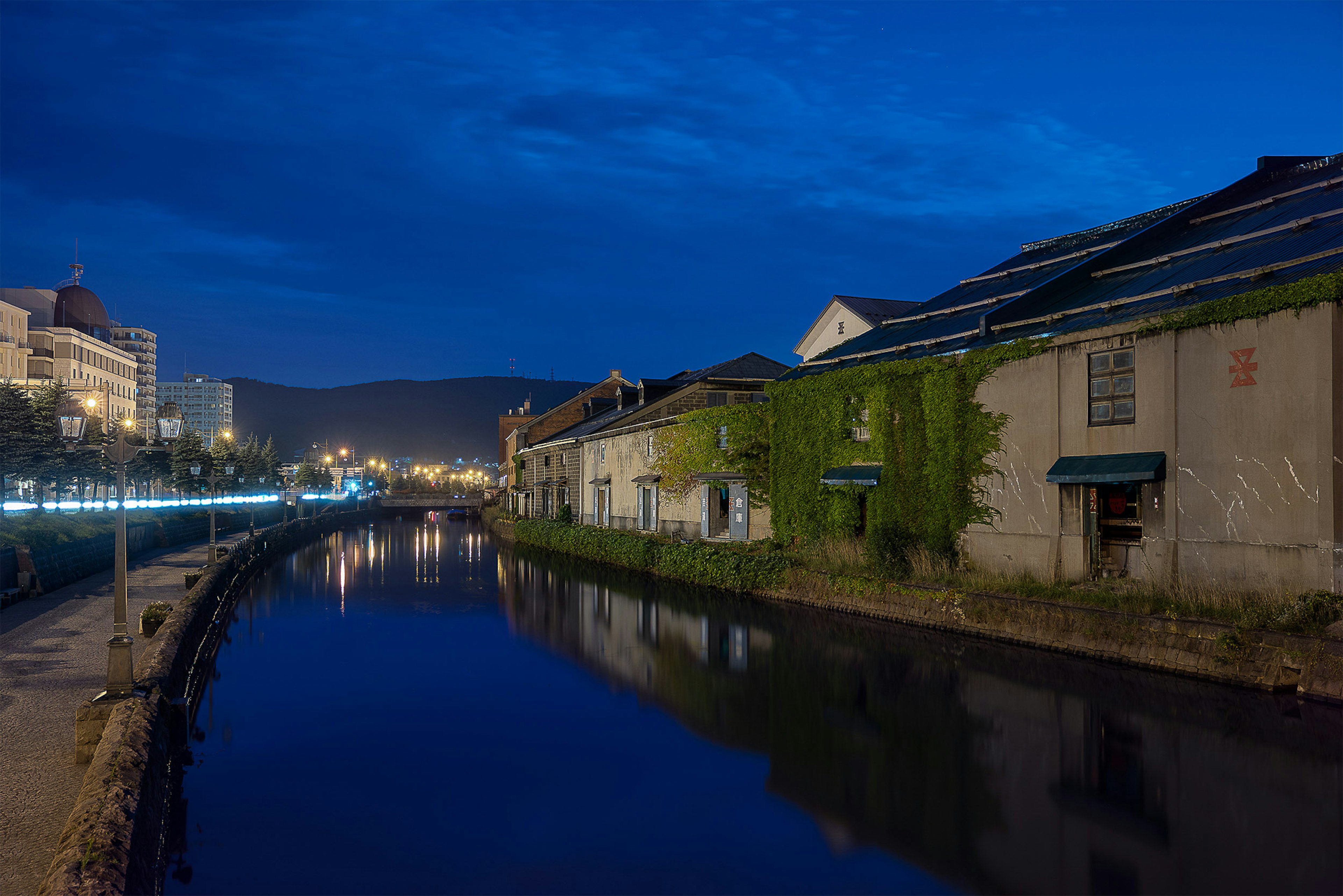 Vista nocturna de un canal con edificios antiguos y reflejos