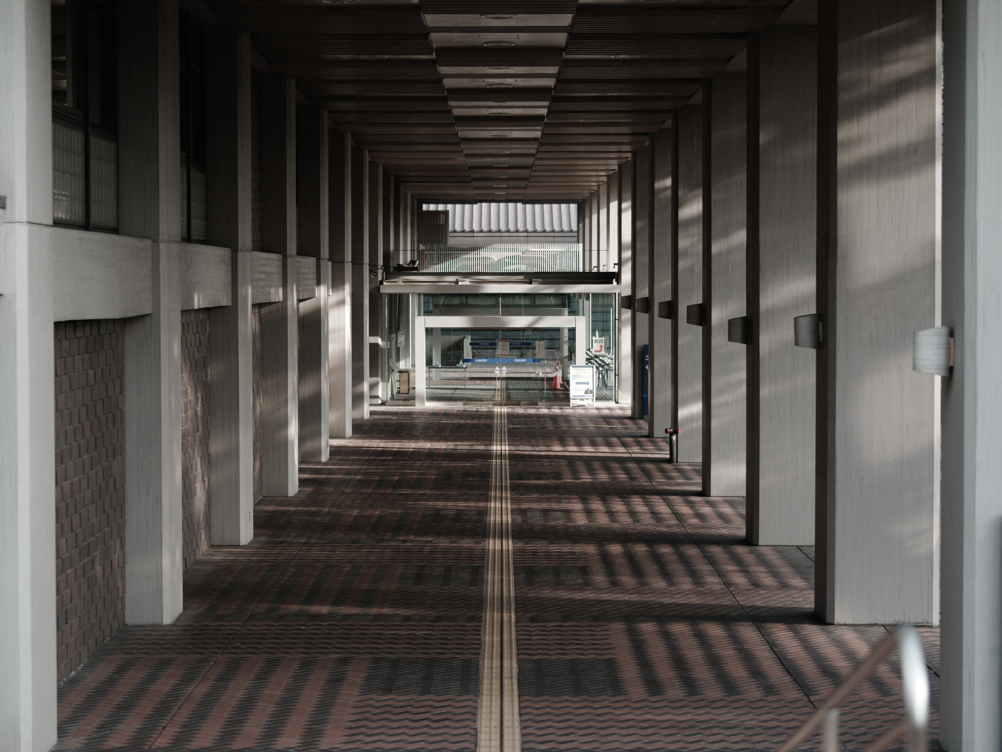 Linear corridor with structural columns and shadow patterns