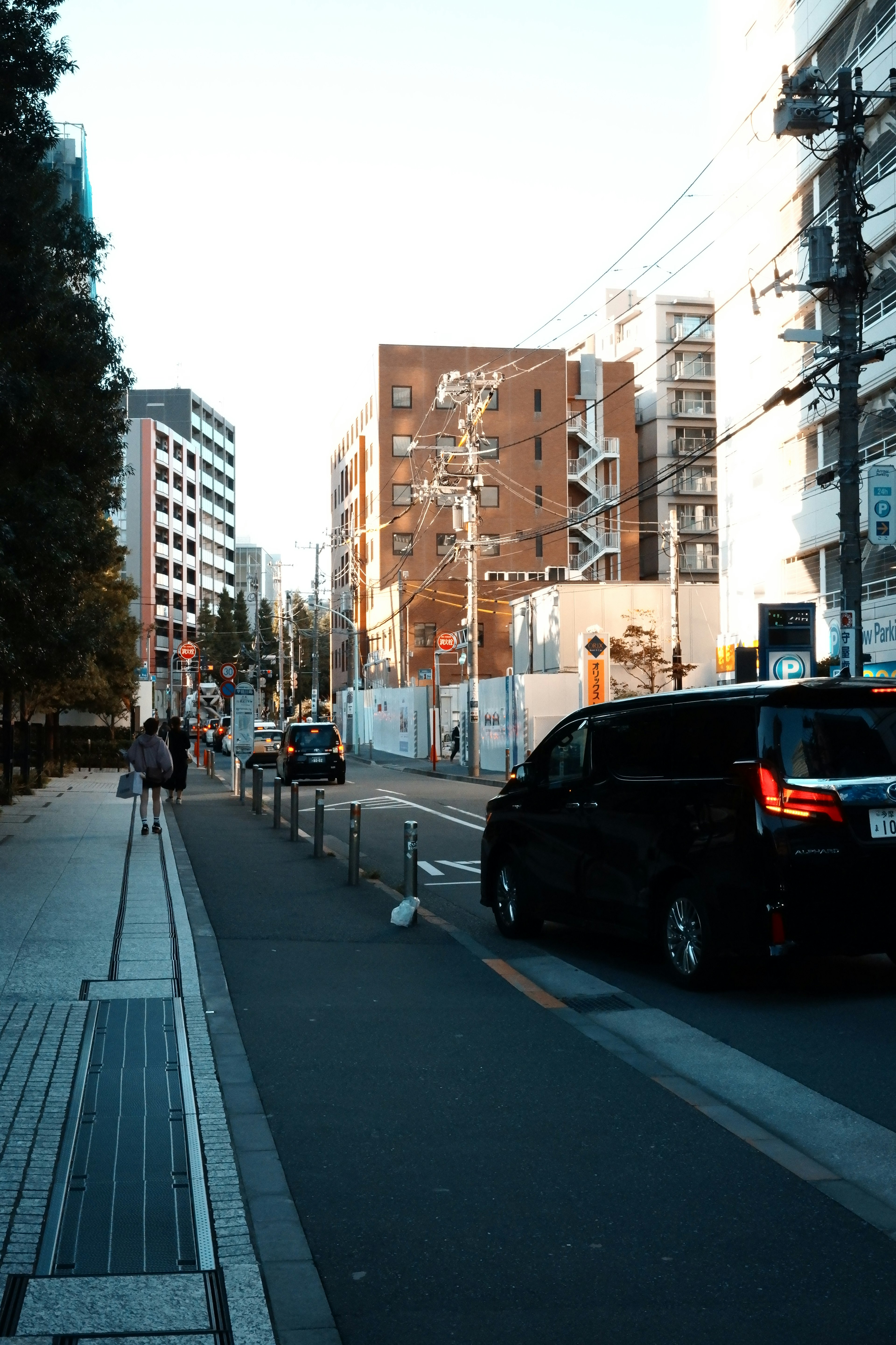 Black car on an urban street with surrounding buildings