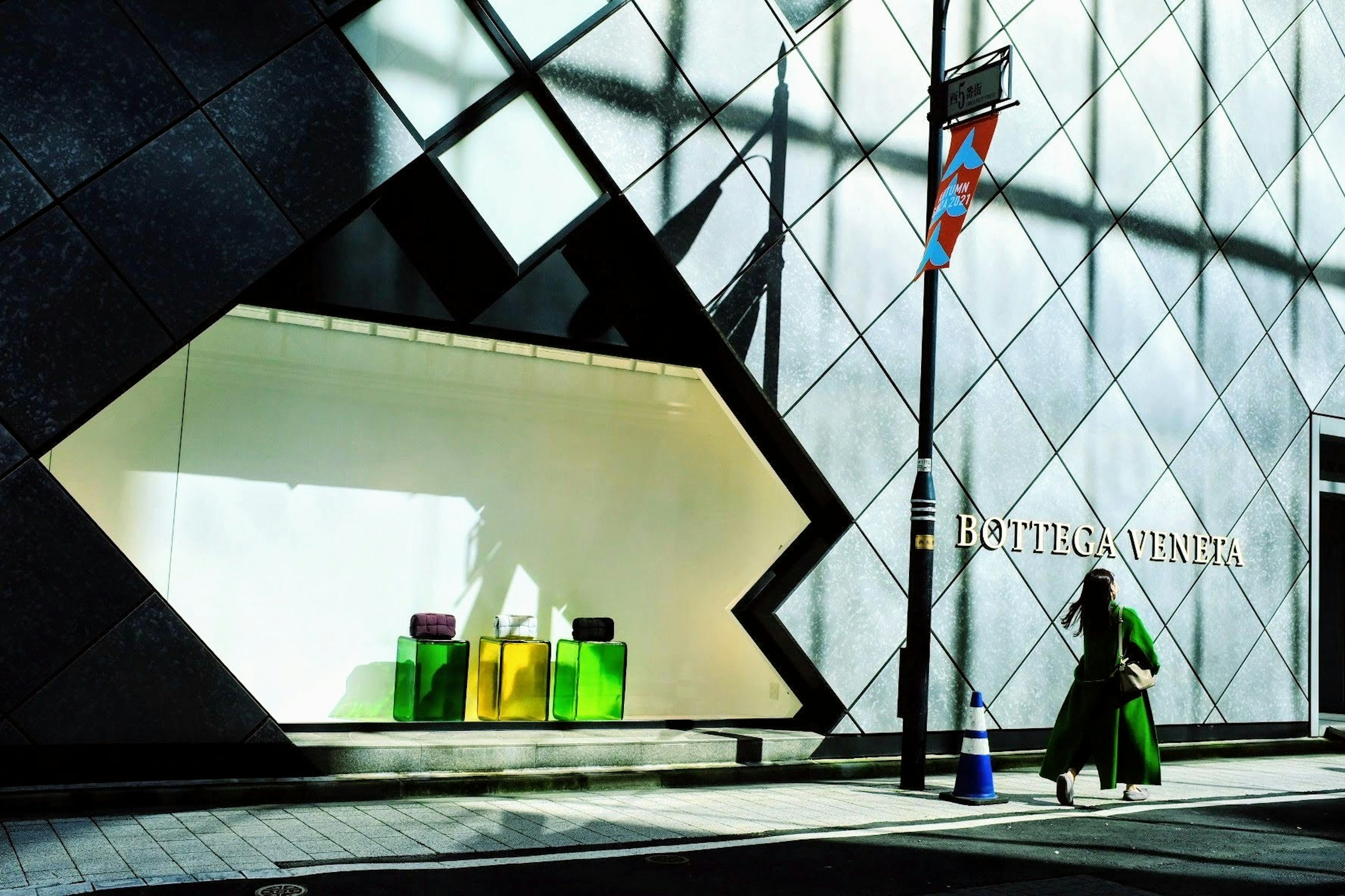 Fachada arquitectónica moderna de la tienda Louis Vuitton con productos coloridos en la ventana