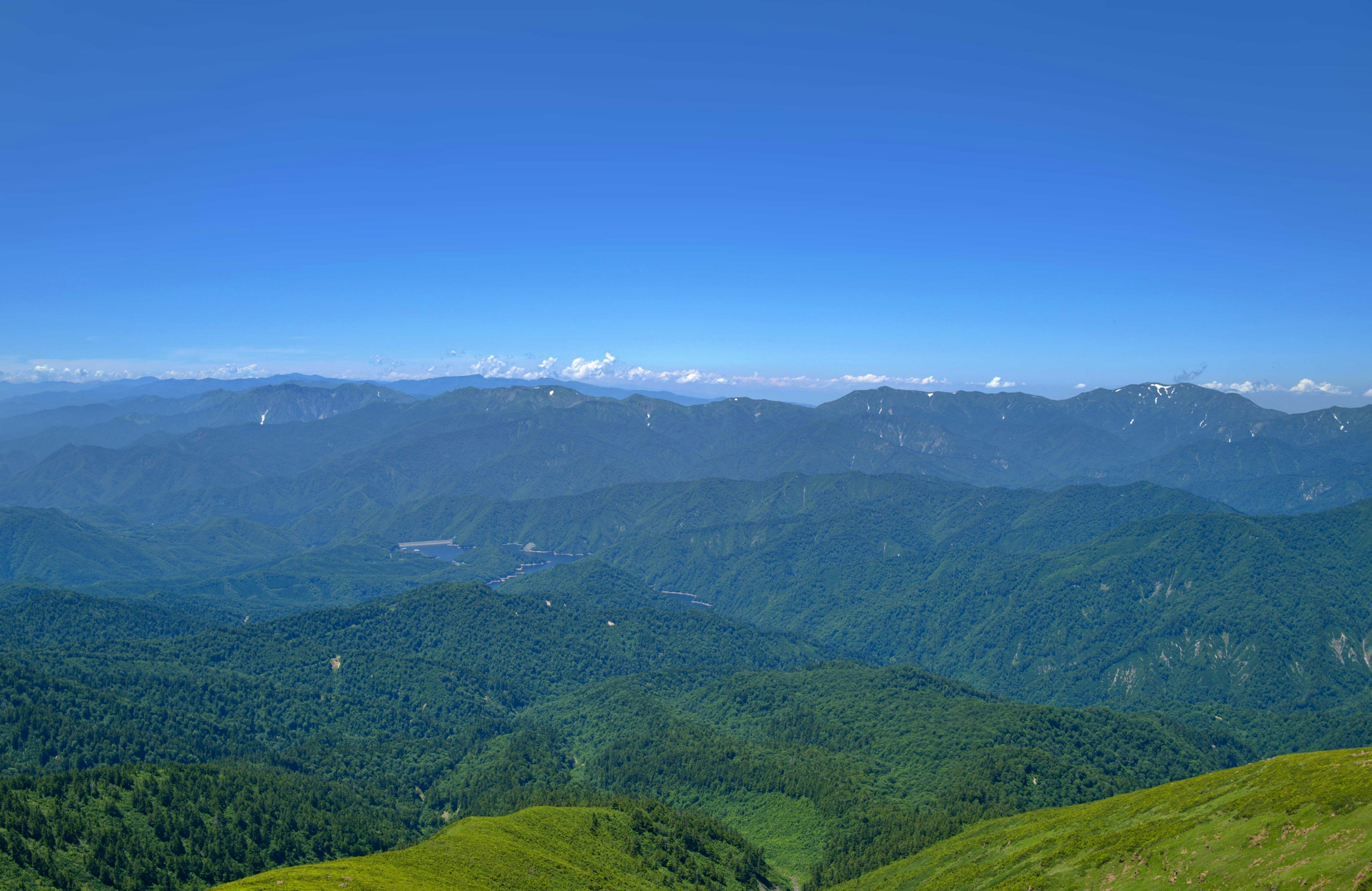 Vista panoramica di montagne verdi sotto un cielo blu