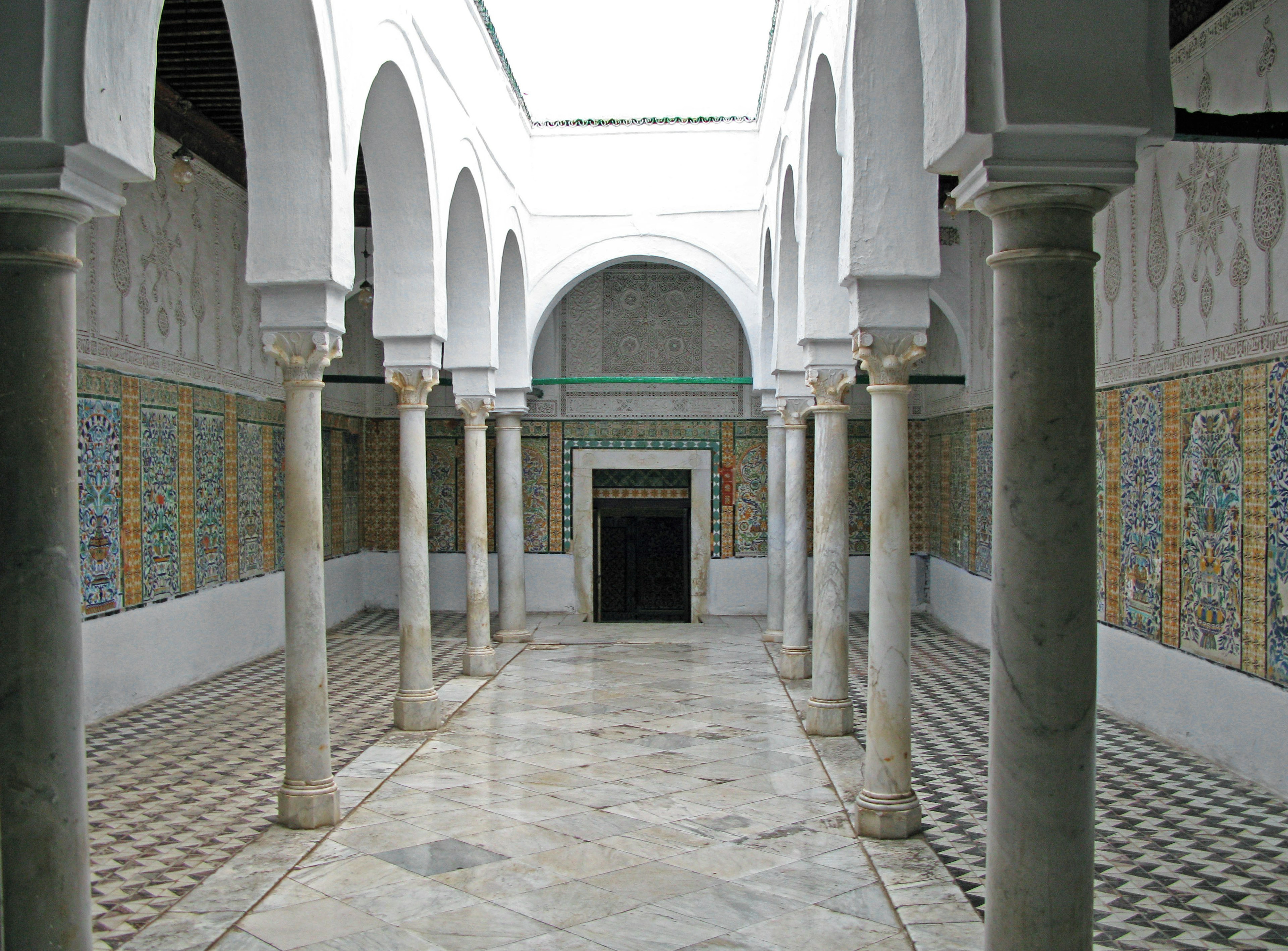 Cour intérieure avec des colonnes blanches et un carrelage complexe