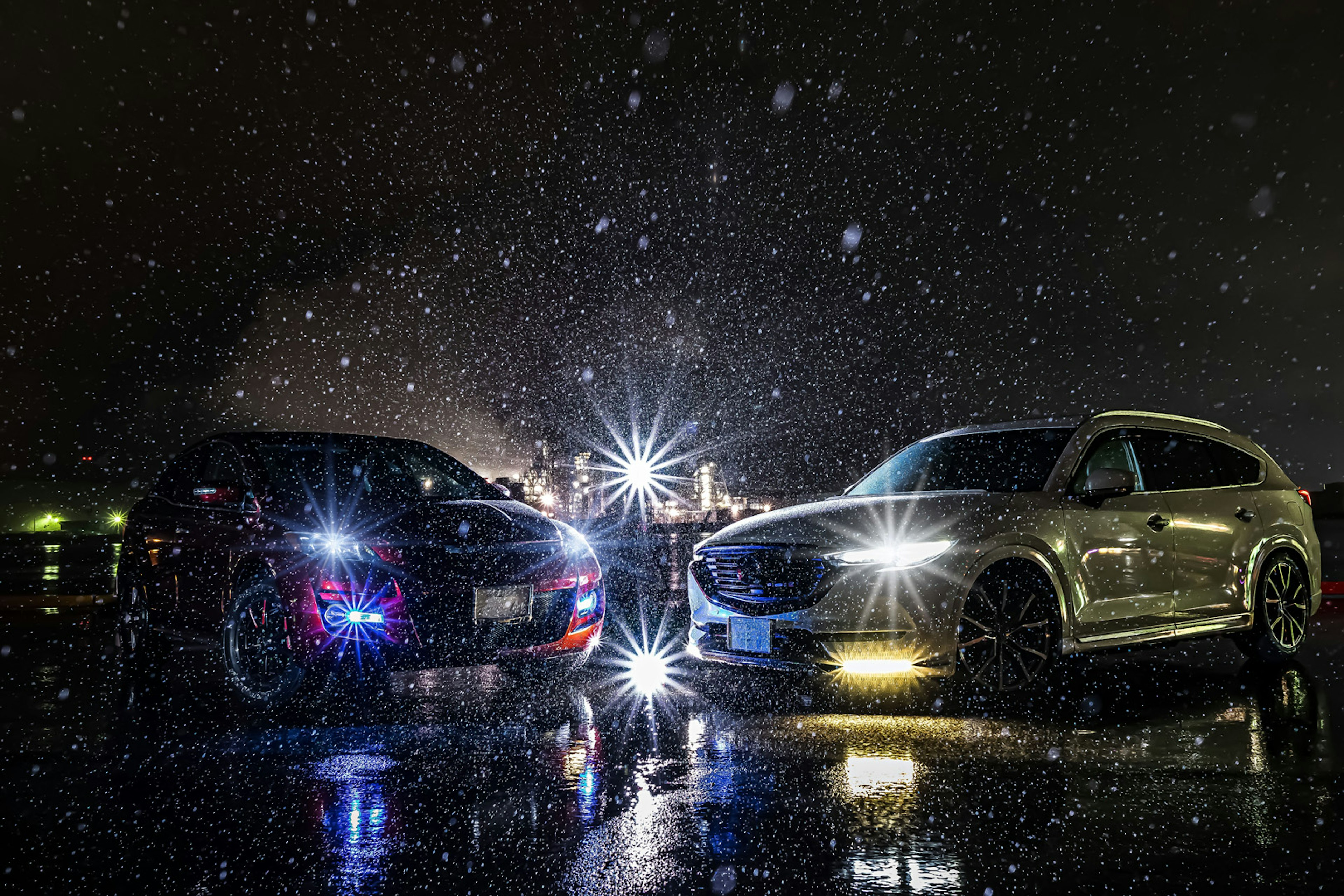 Dos coches iluminados bajo la lluvia por la noche con luces brillantes