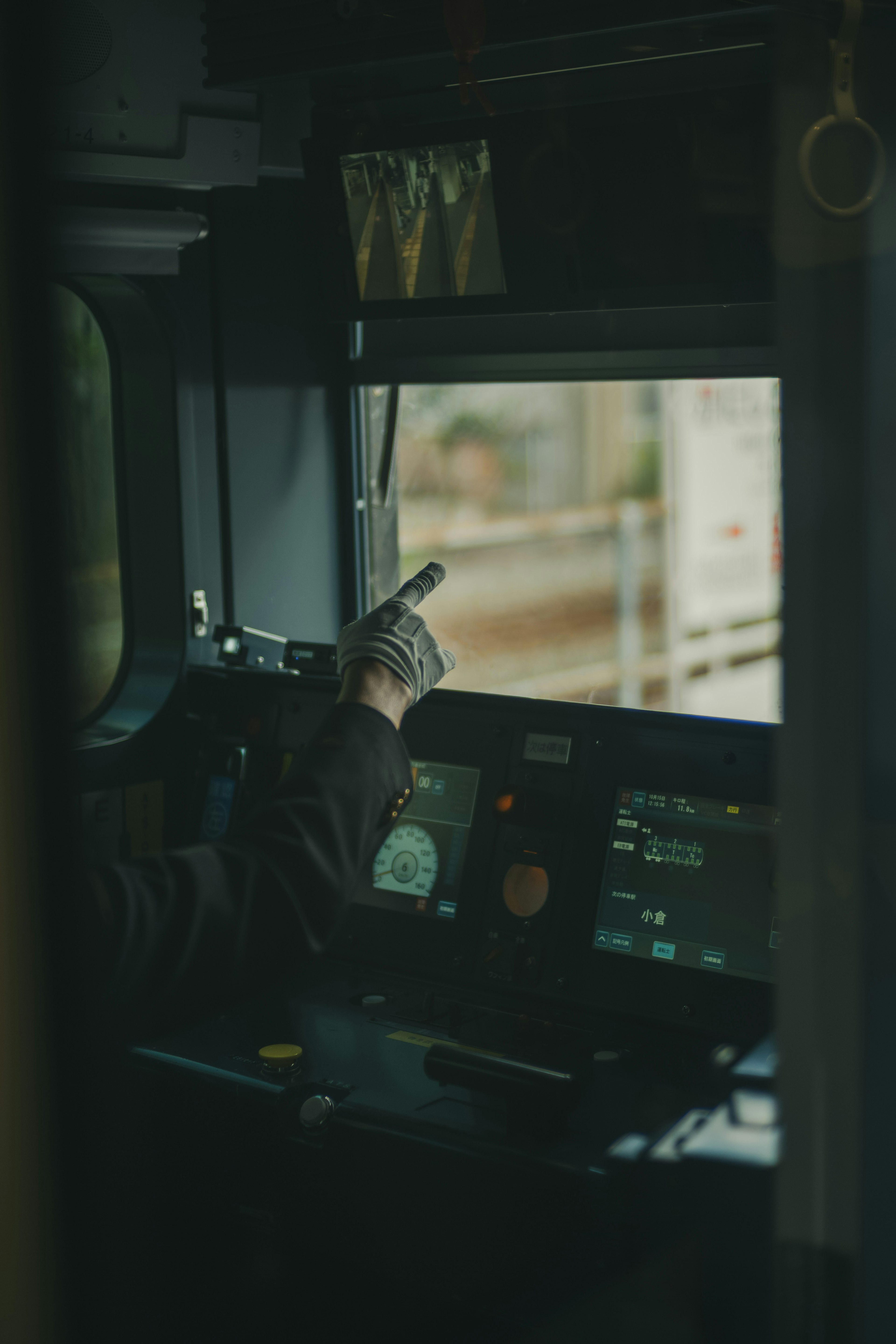 Conductor pointing outside from the train cabin