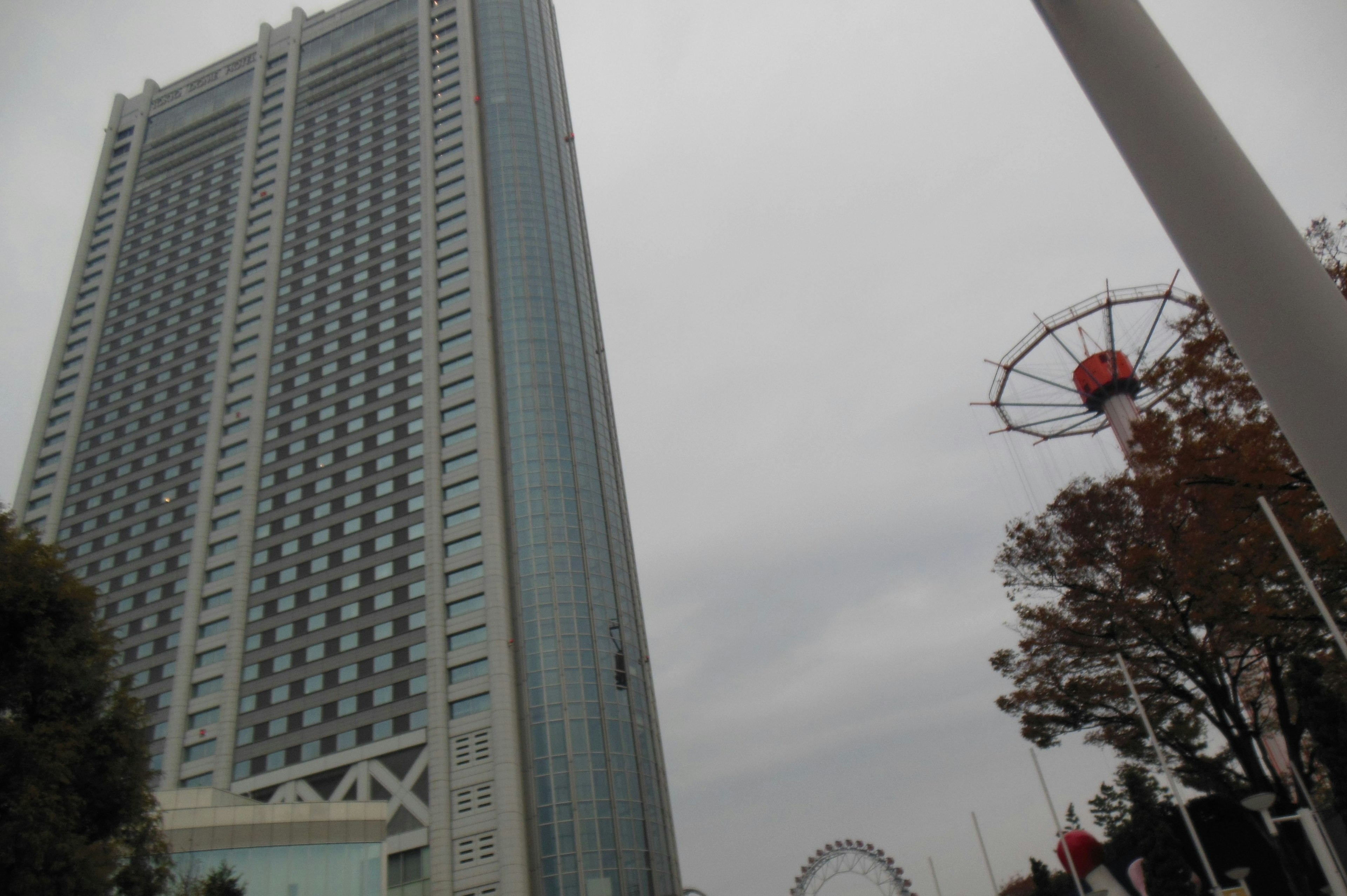 Pemandangan gedung pencakar langit dengan roda ferris di latar belakang