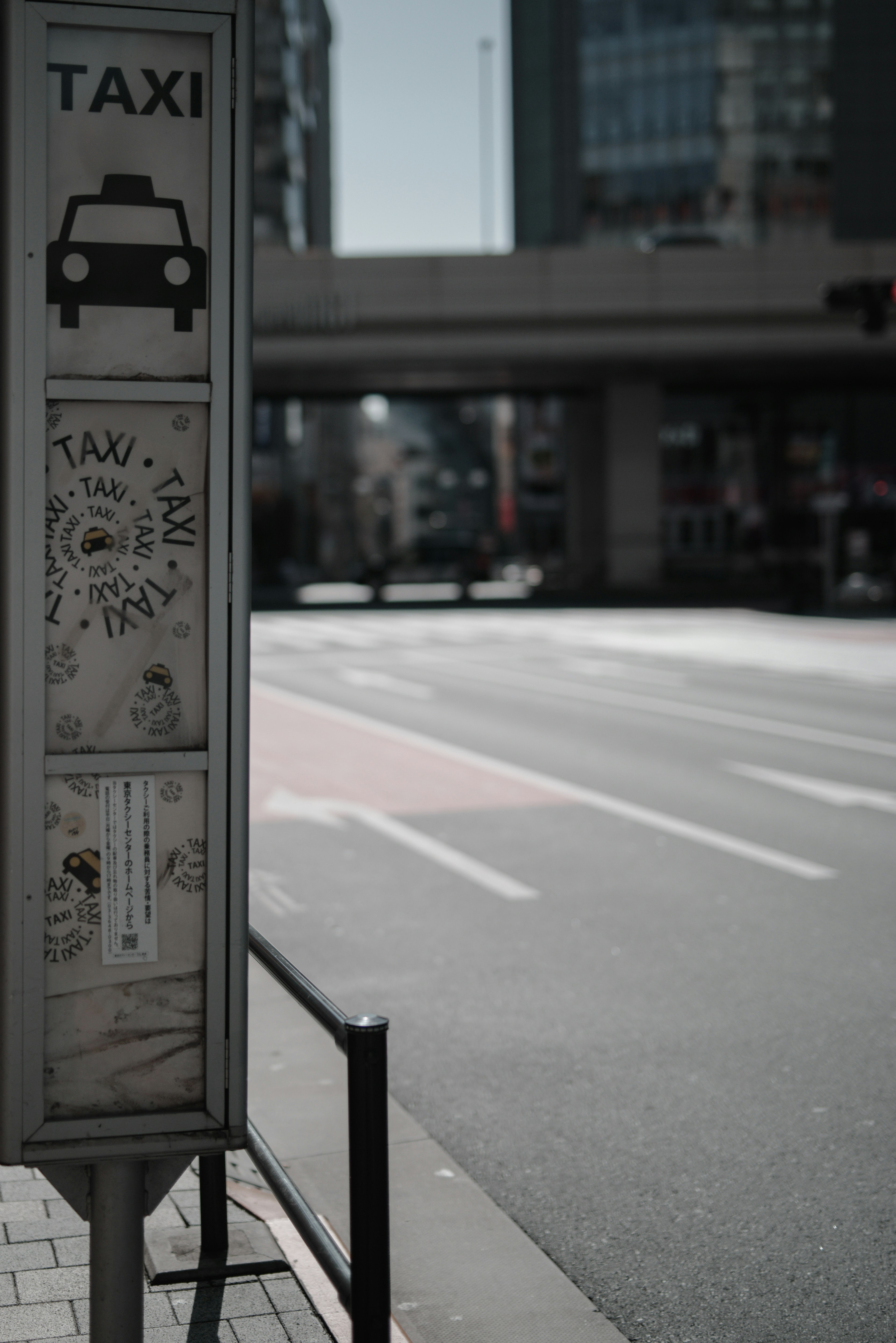 タクシーの看板があるバス停と空の道路