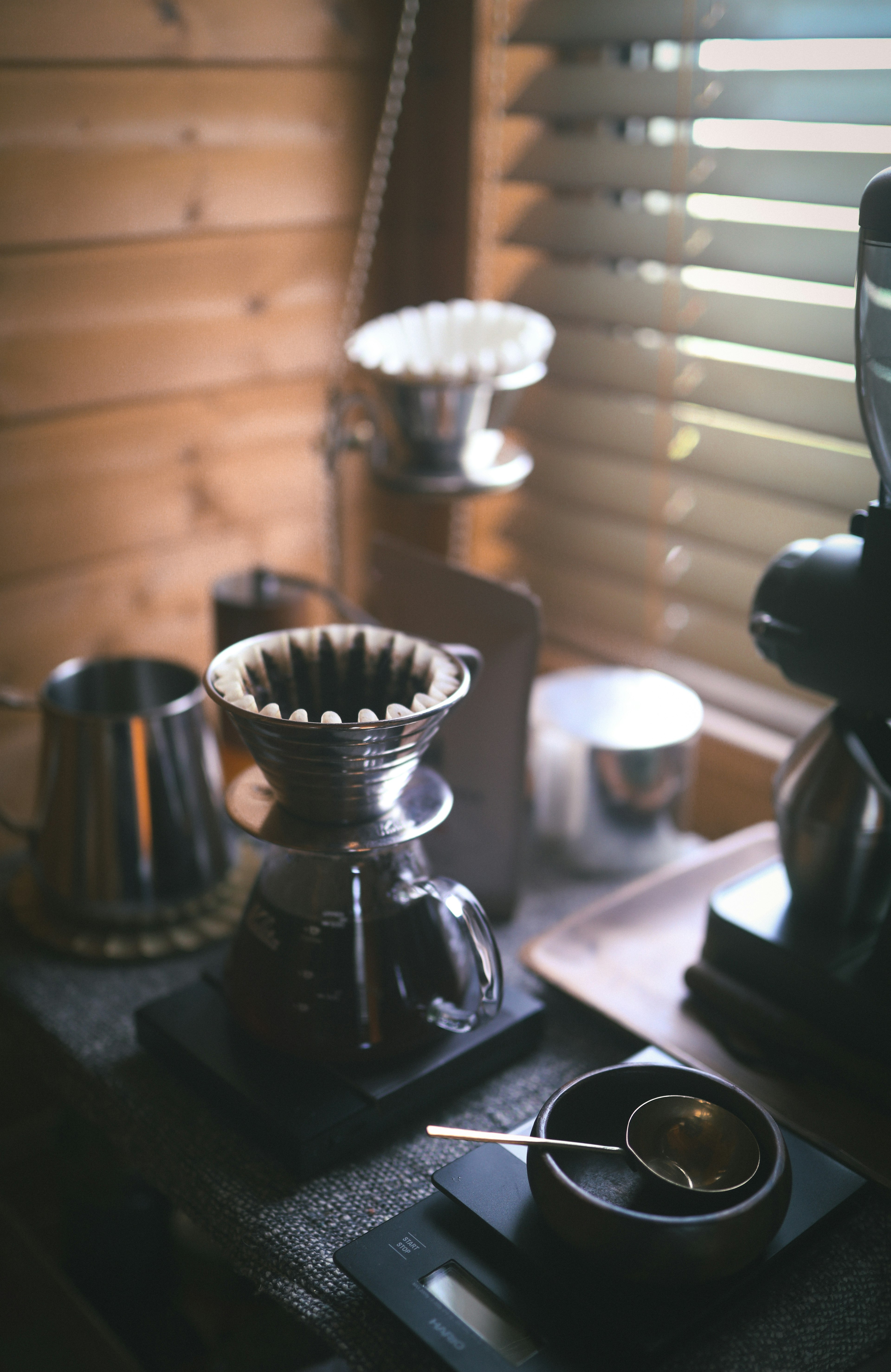 Coffee brewing equipment on a counter with wooden wall