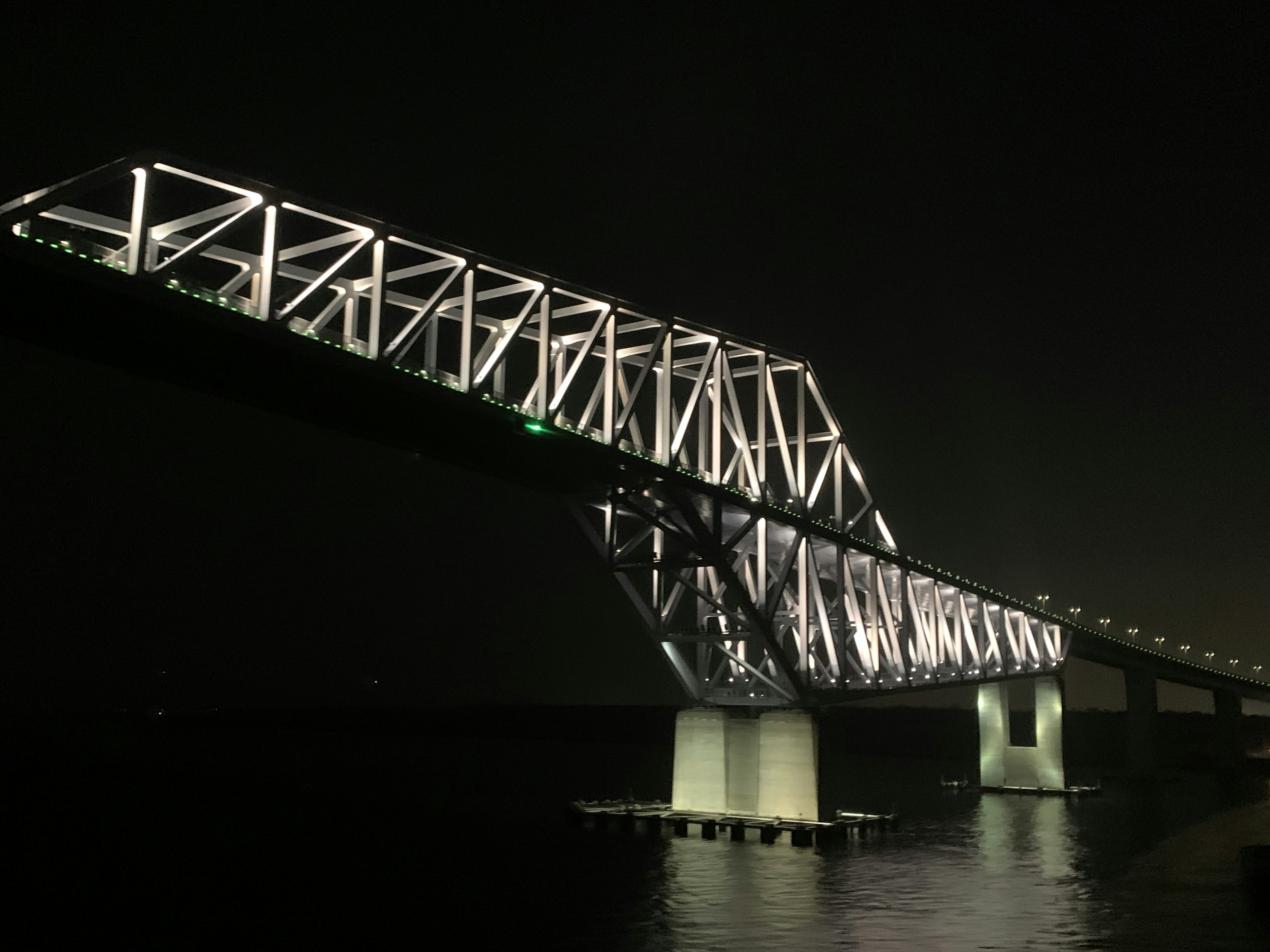 Struktur jembatan yang diterangi di malam hari