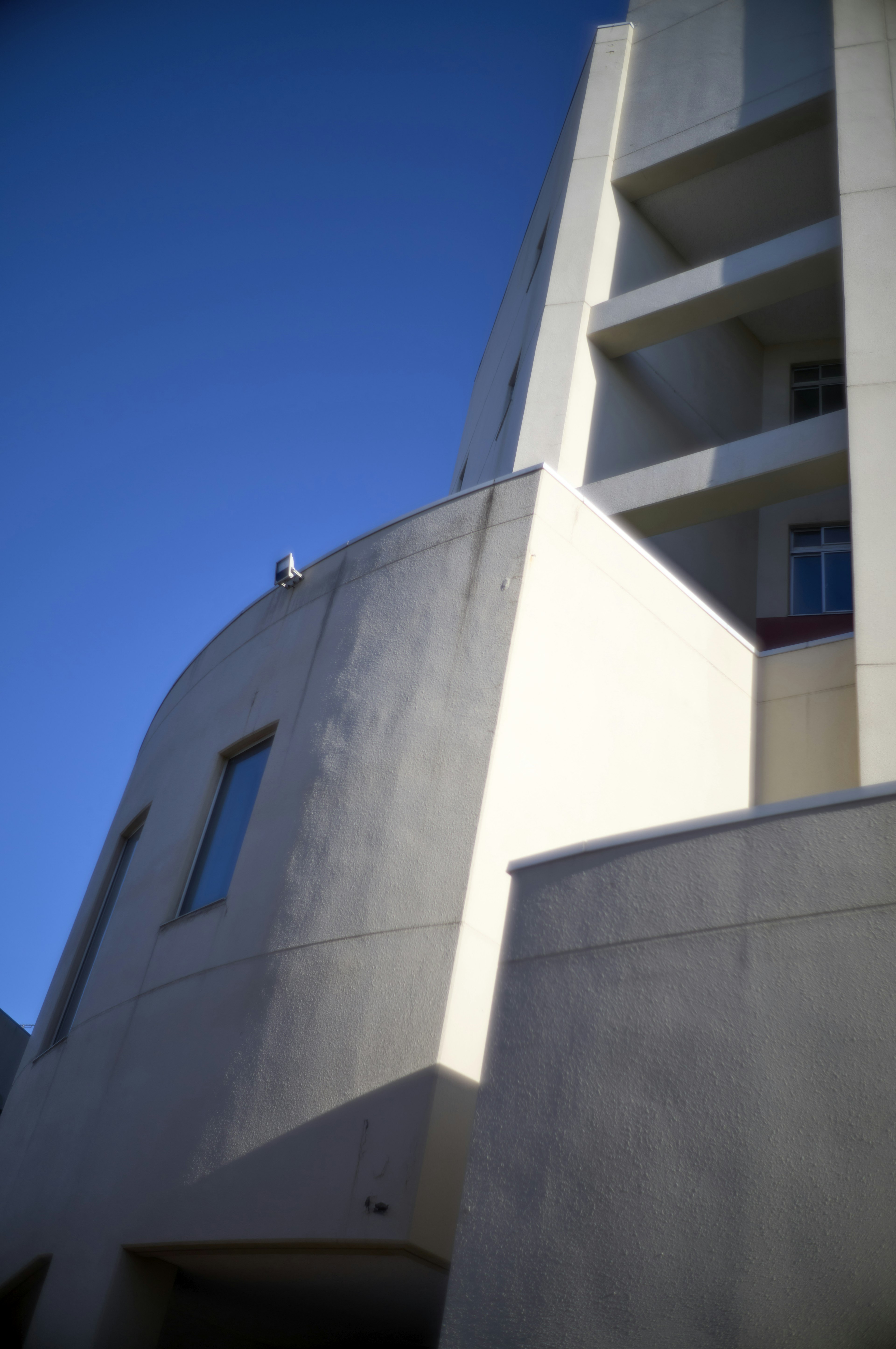 Esquina de un edificio moderno con fondo de cielo azul