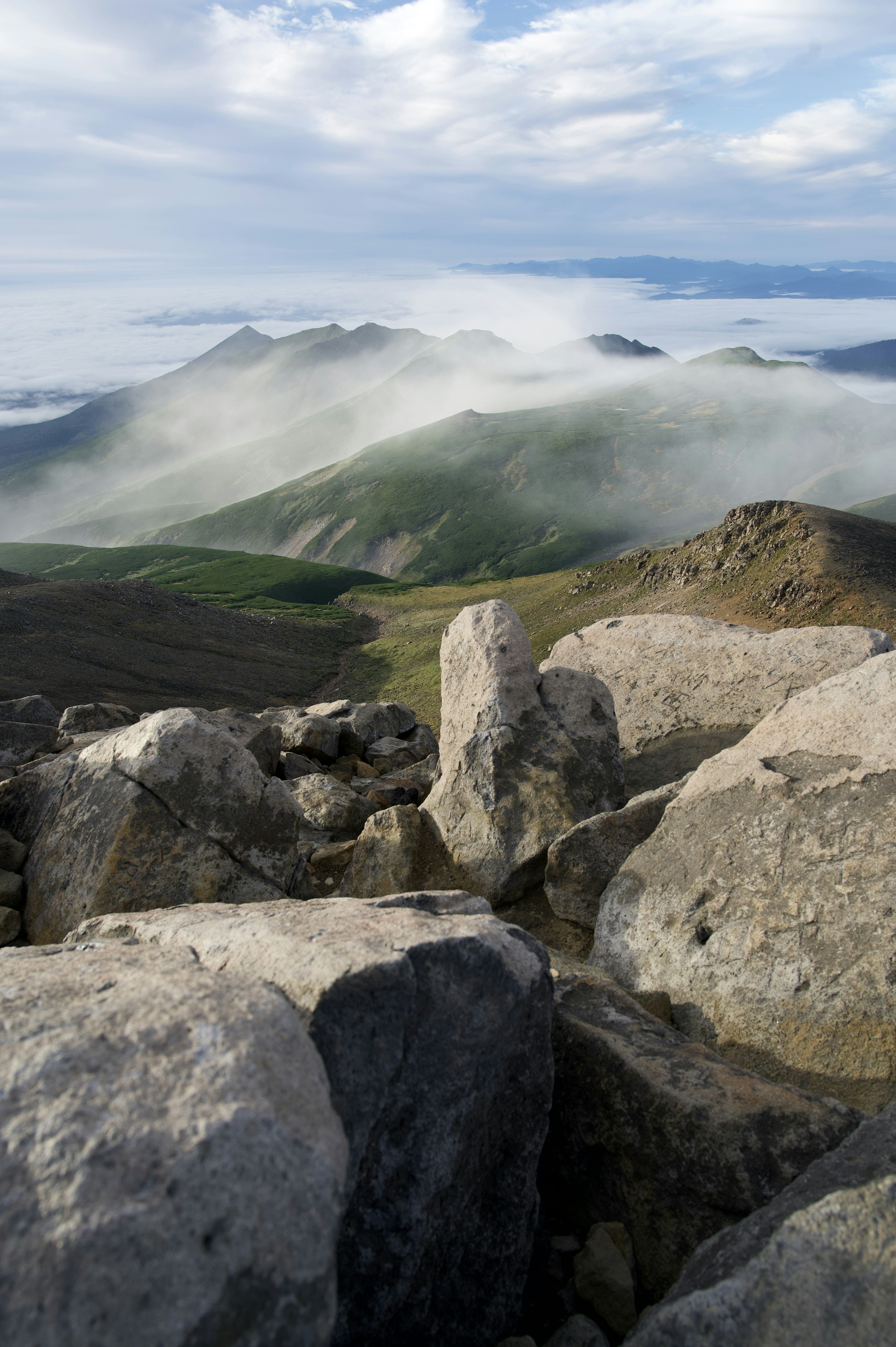 Landschaft mit Bergen in Nebel gehüllt und steinigem Vordergrund