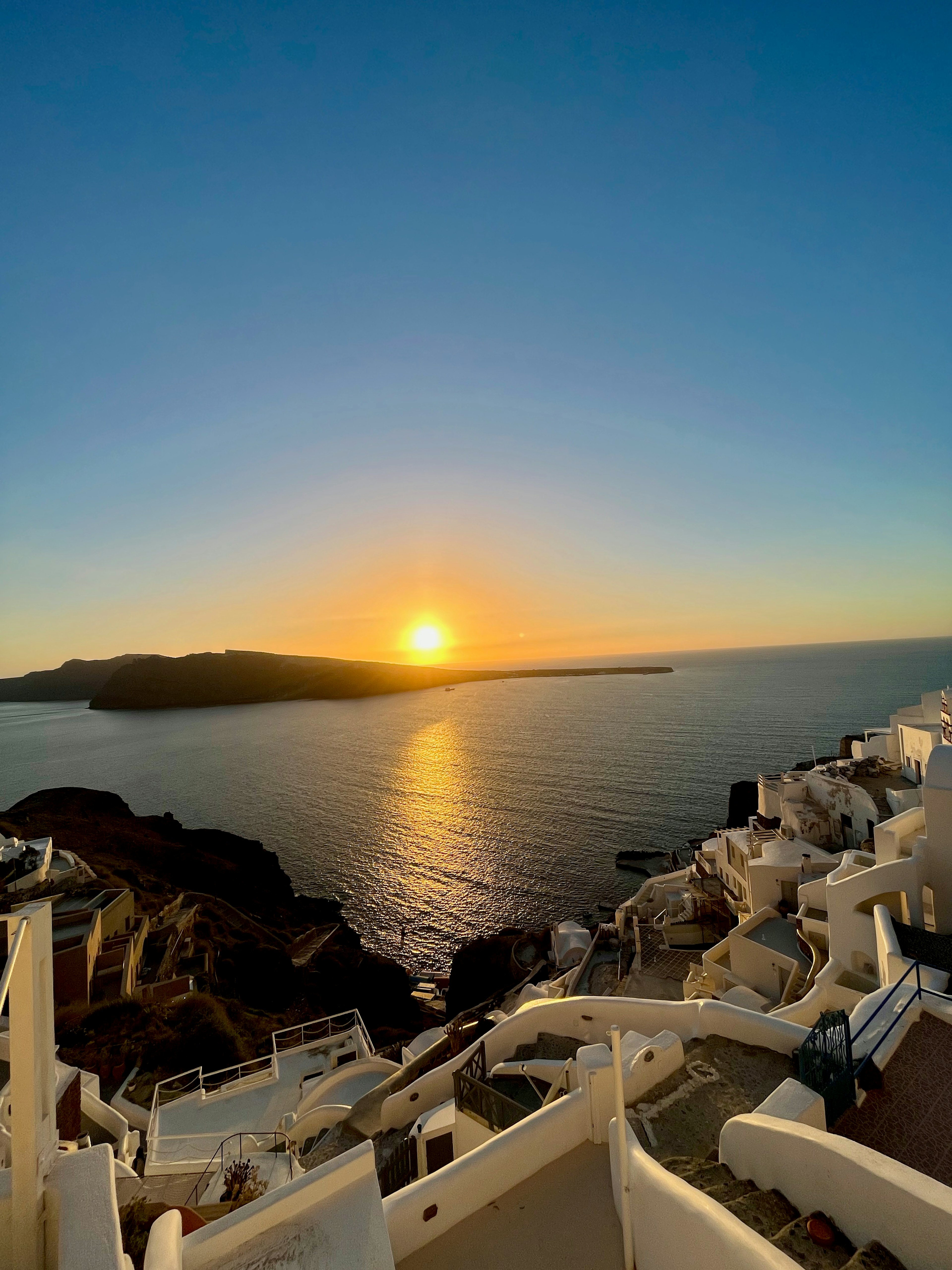 Insel Santorin mit weißen Gebäuden und Sonnenuntergang über dem Meer