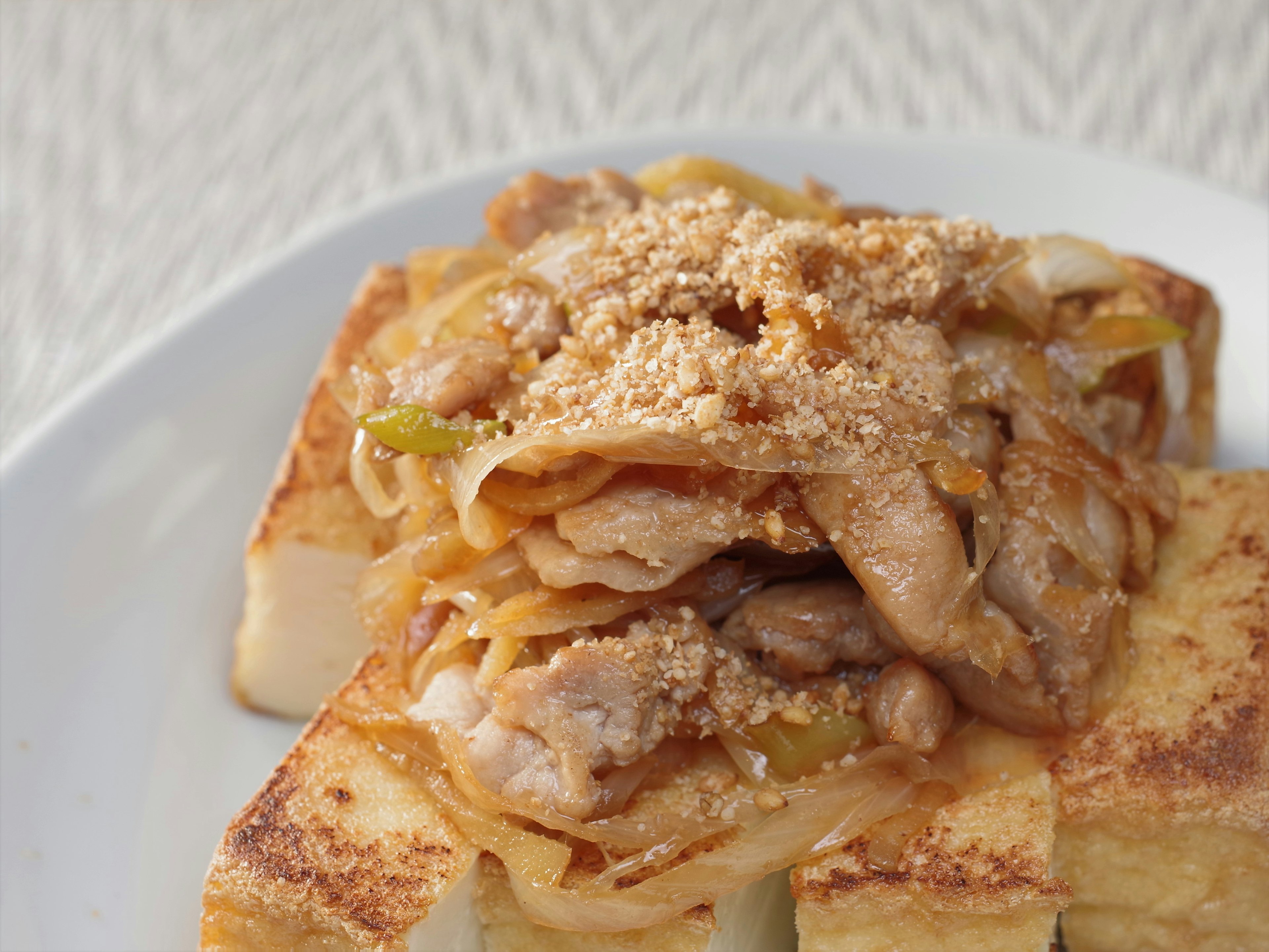 Une assiette de pain grillé surmontée de poulet et de légumes