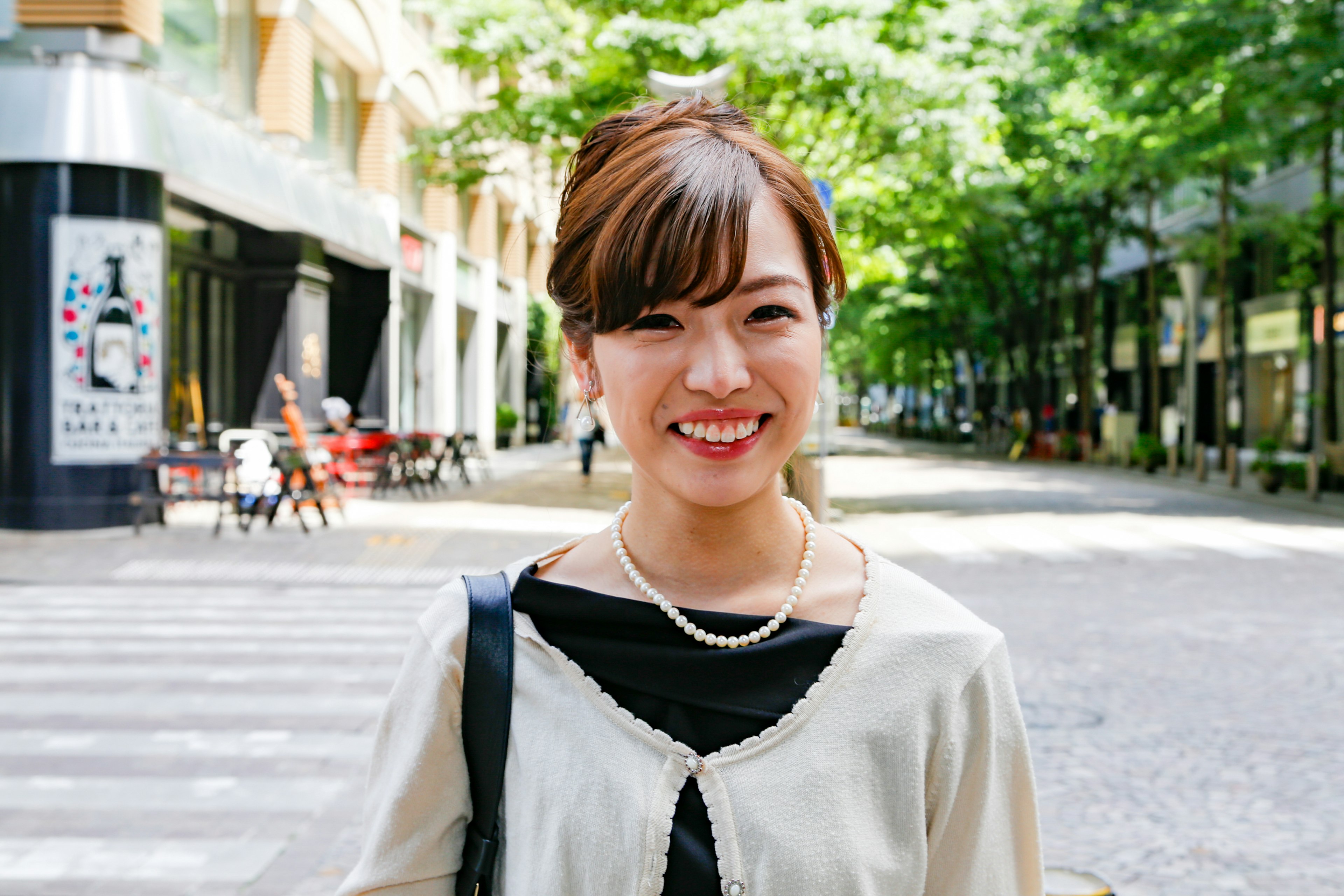 Portrait d'une femme souriante dans la ville entourée d'arbres verts dans la rue