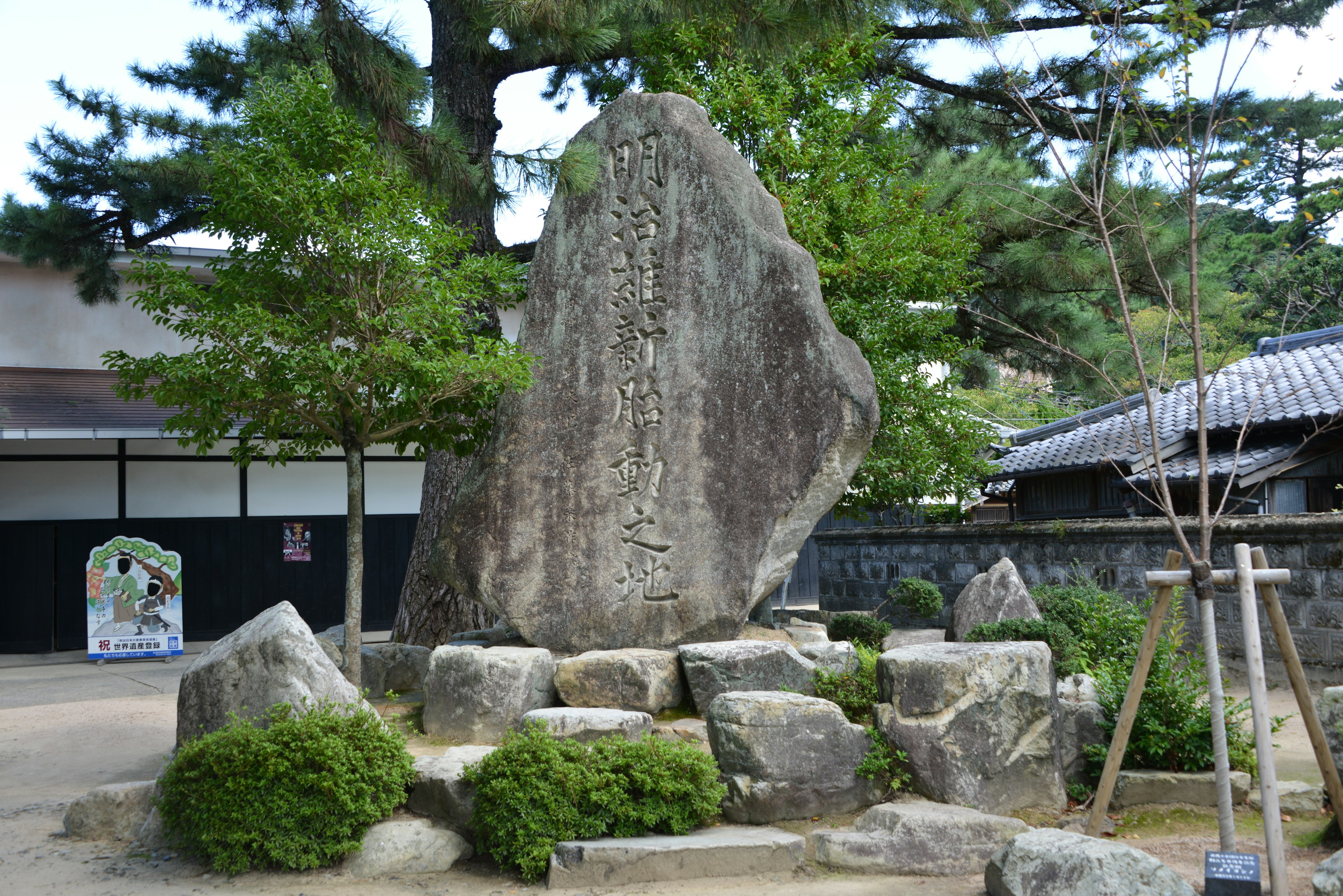 주변의 녹지와 함께 있는 큰 돌이 있는 일본 정원