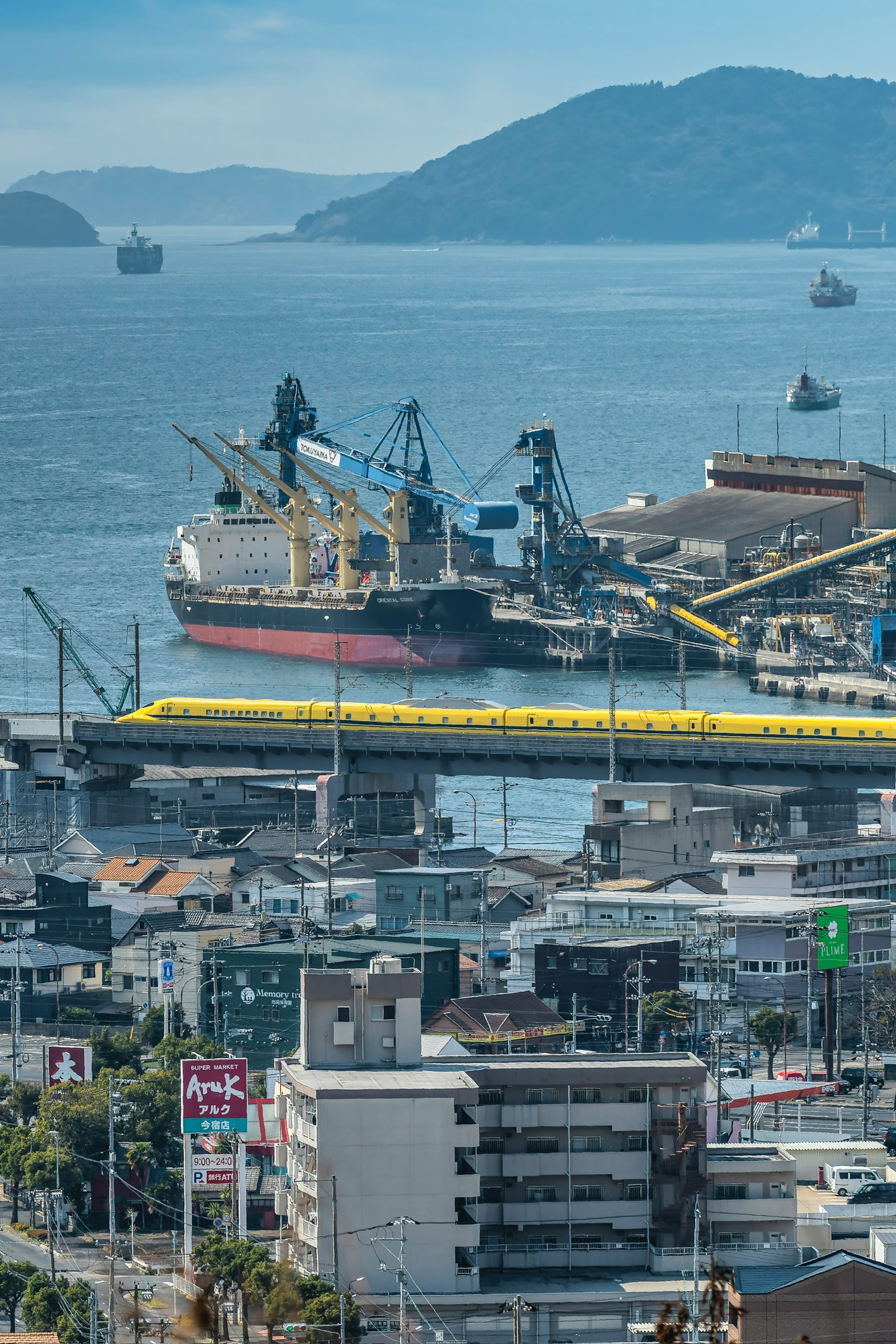 View of a cargo ship docked at the port with surrounding buildings