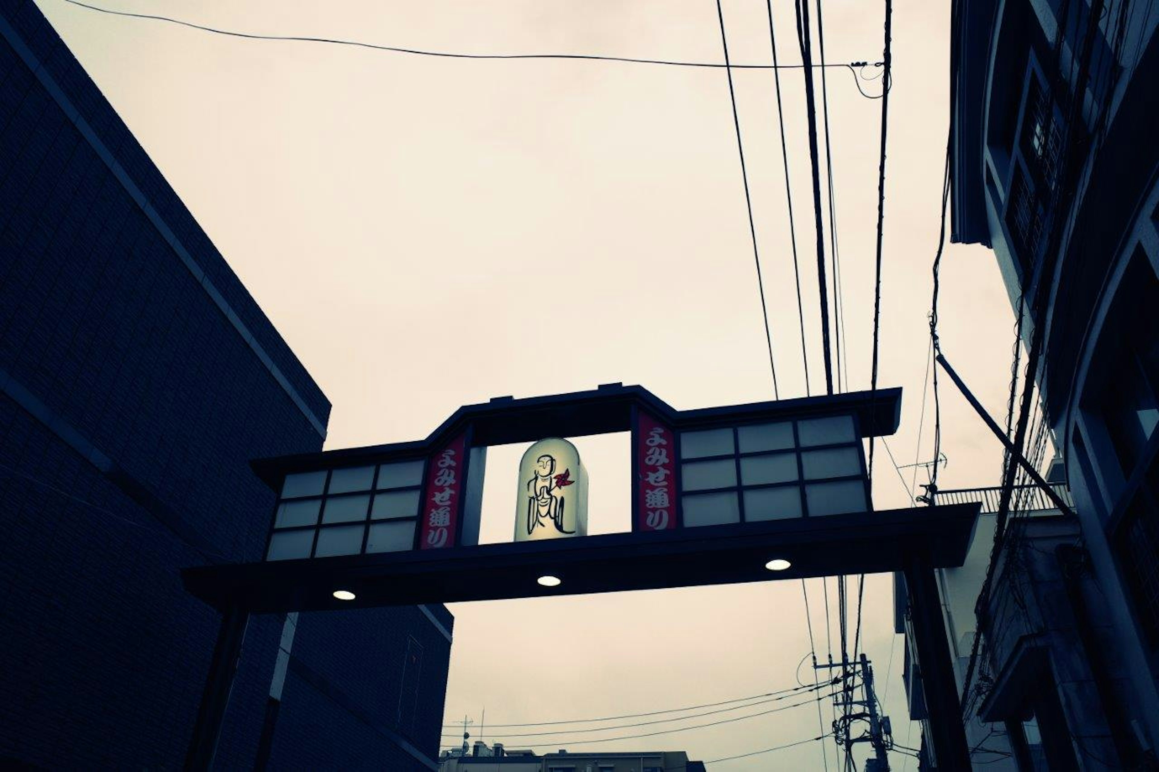 Arco urbano con letrero bajo un cielo gris