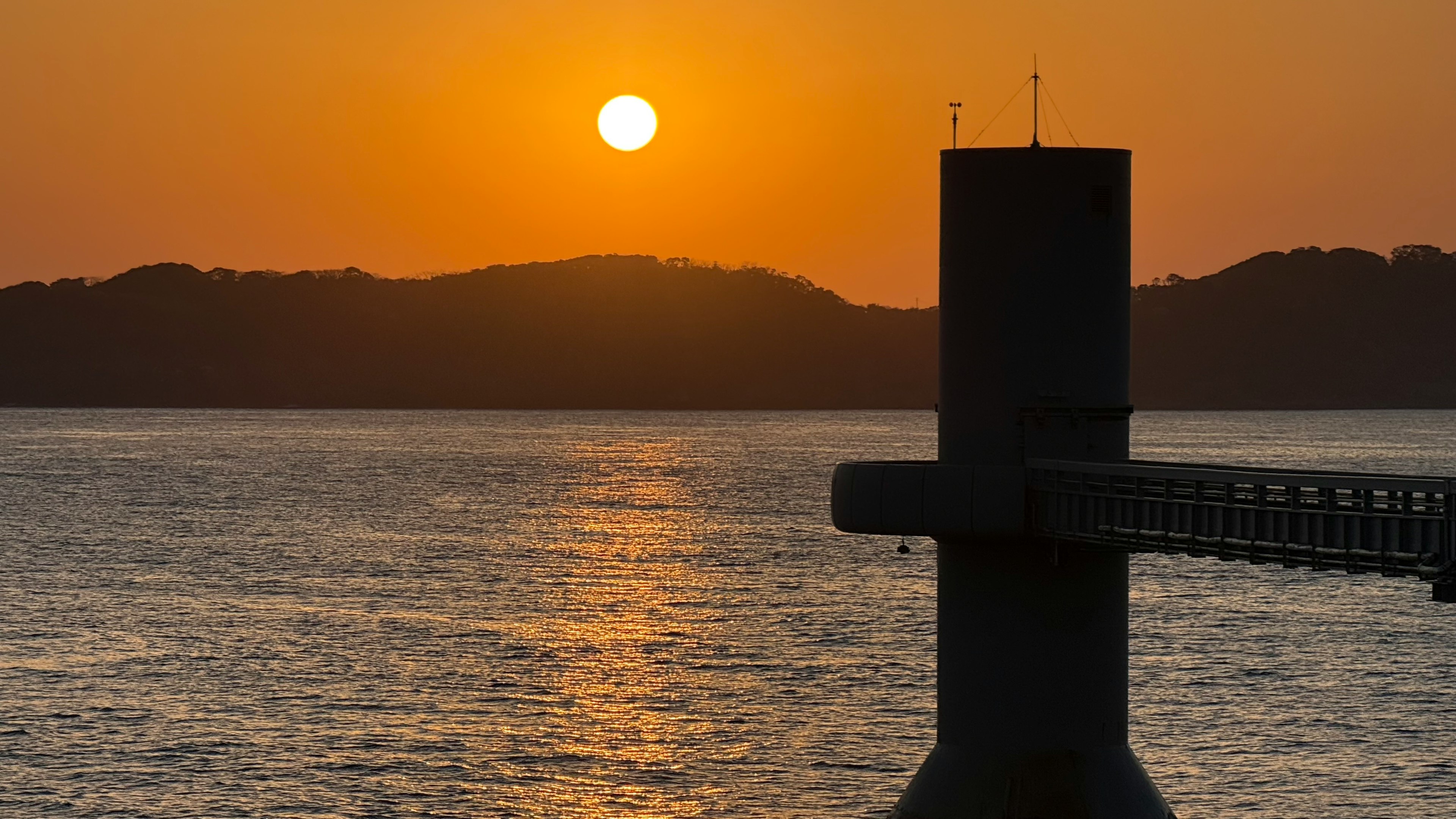 Tramonto sull'oceano con una struttura del molo