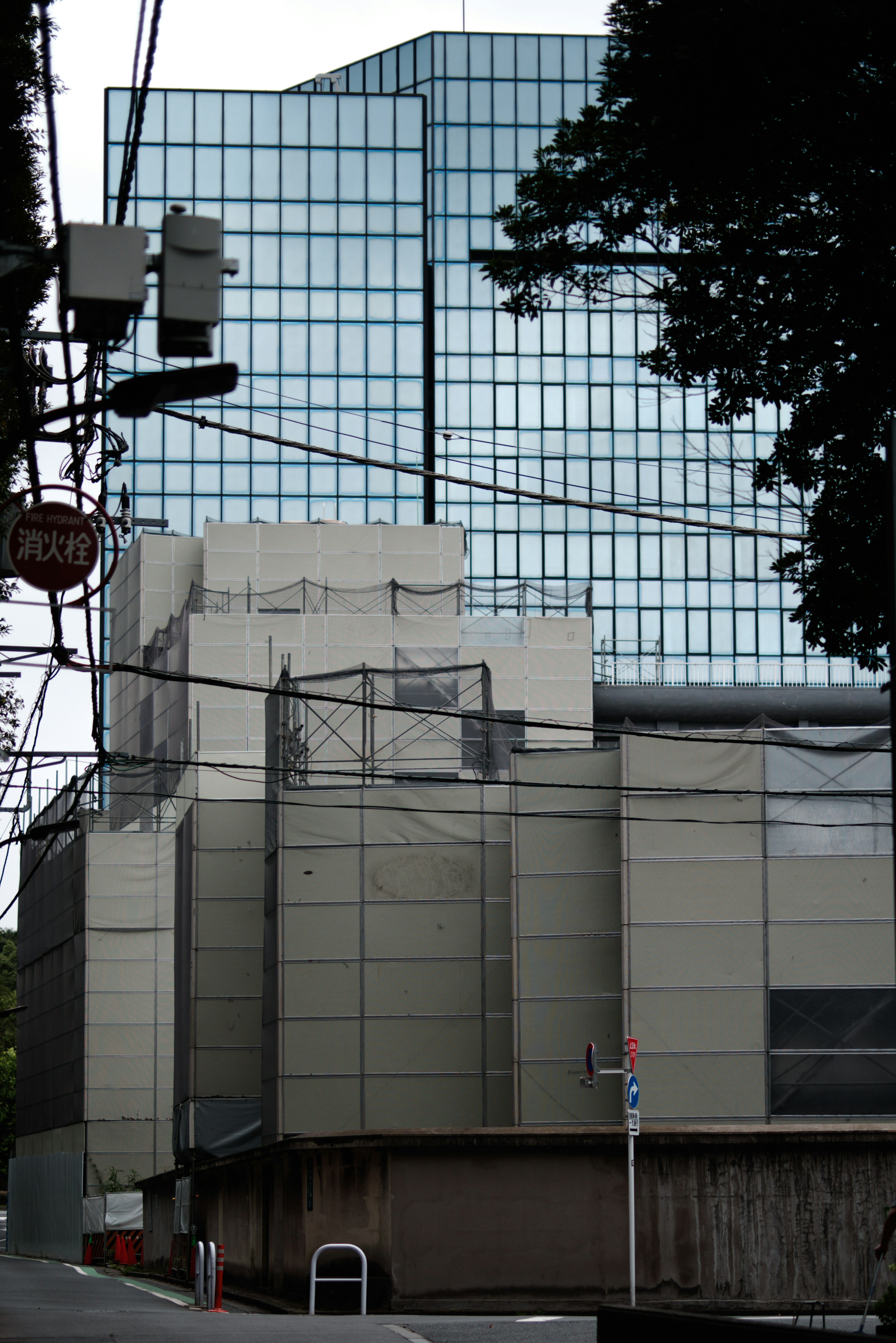 Paysage urbain avec un bâtiment à façade en verre et des lignes électriques environnantes