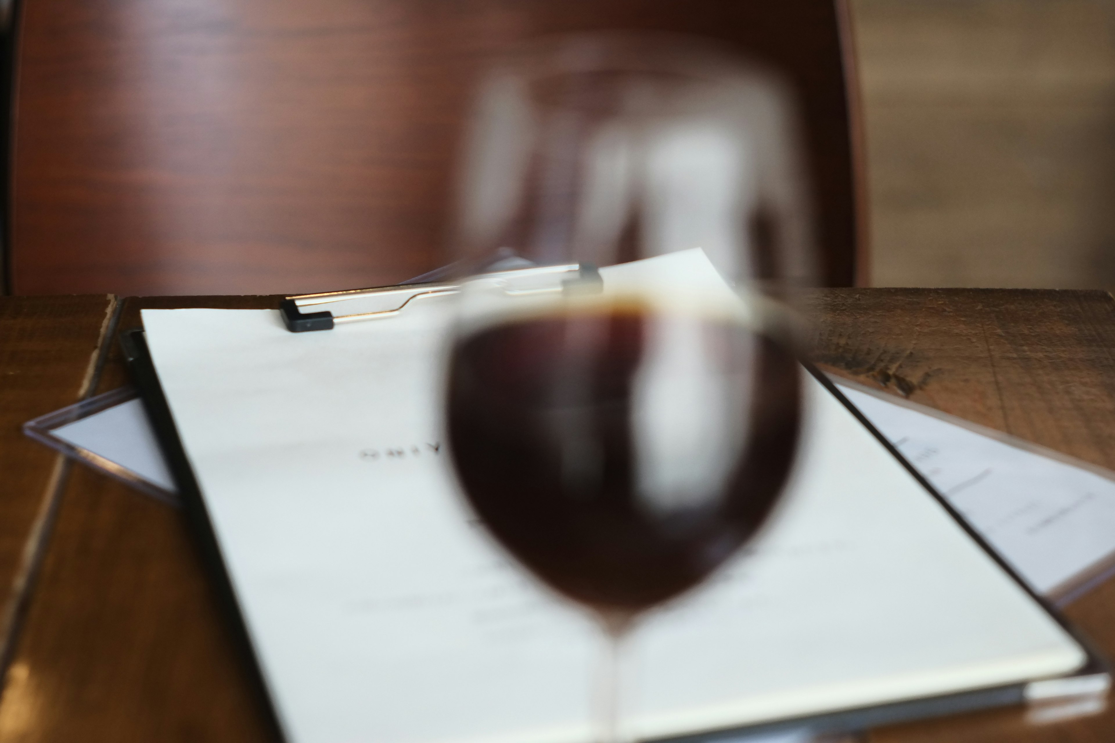 Verre de vin rouge flou avec un menu sur la table