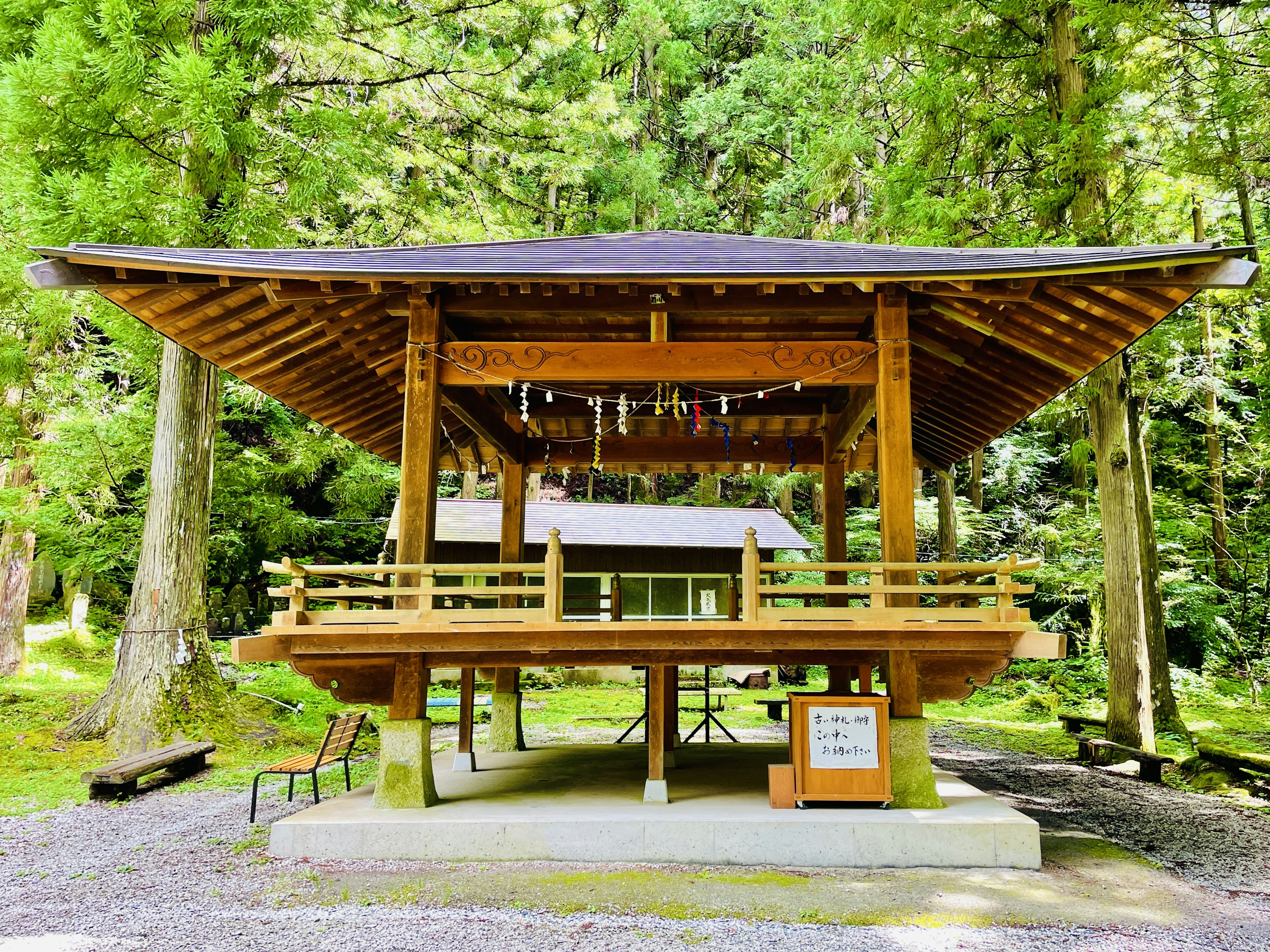 森の中にある木製の神社のような建物で屋根が特徴的