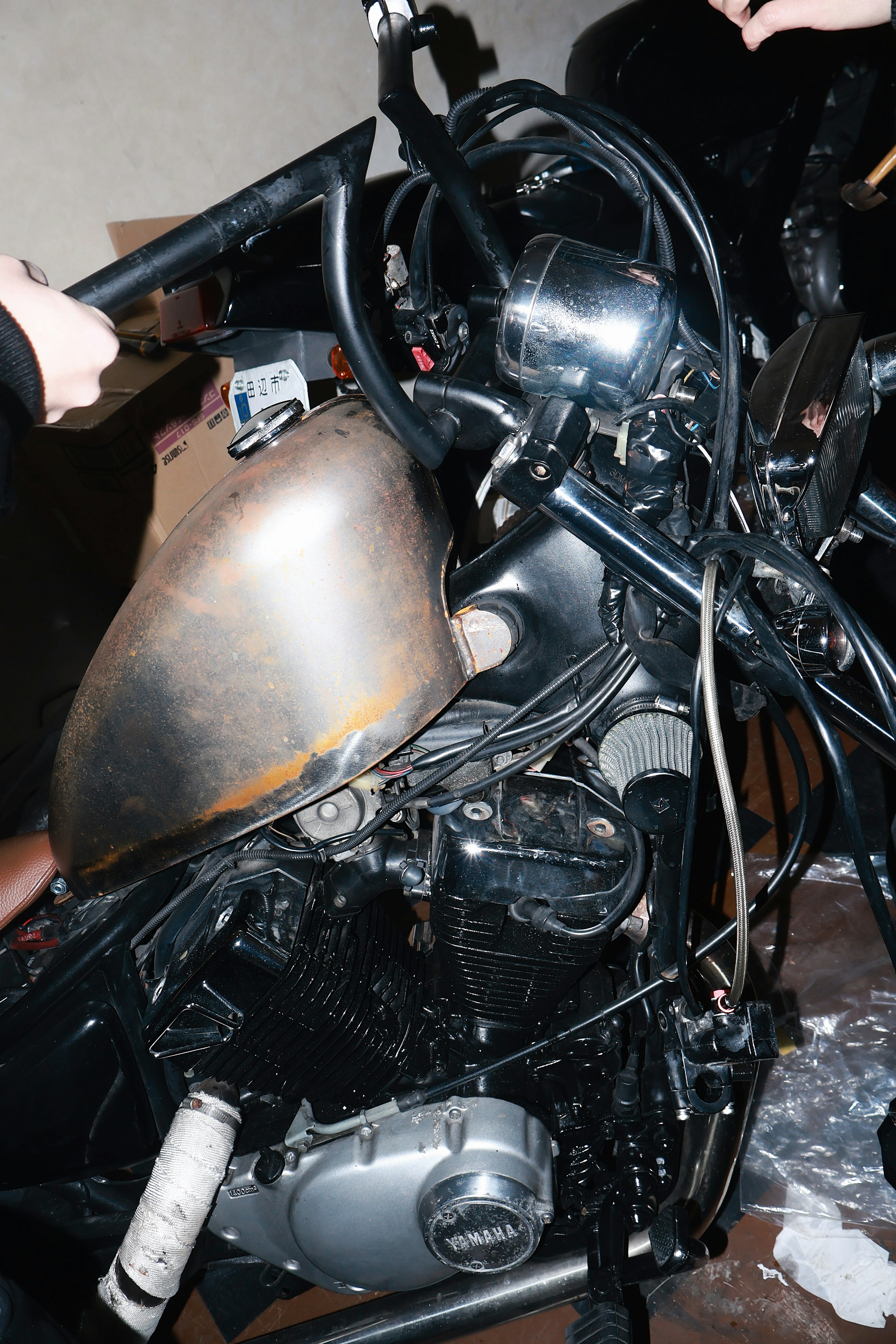 Close-up of a motorcycle engine and handlebars showcasing metallic textures and complex wiring