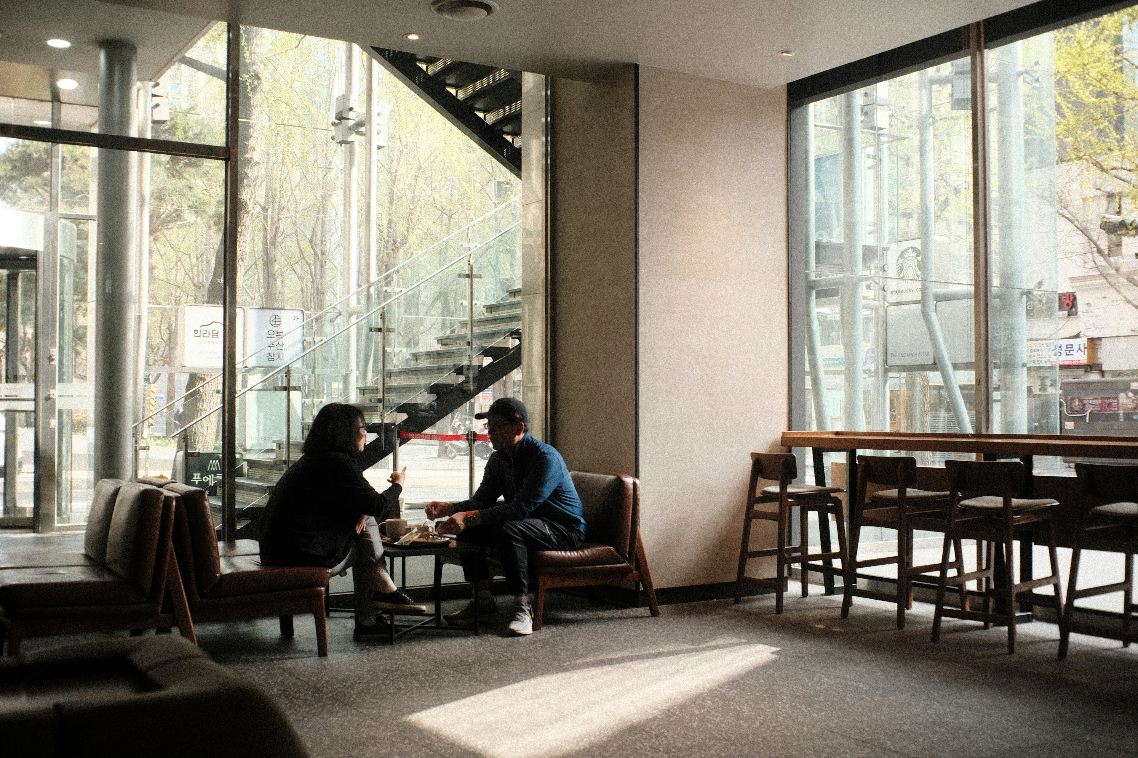 A bright café interior with two people engaged in conversation