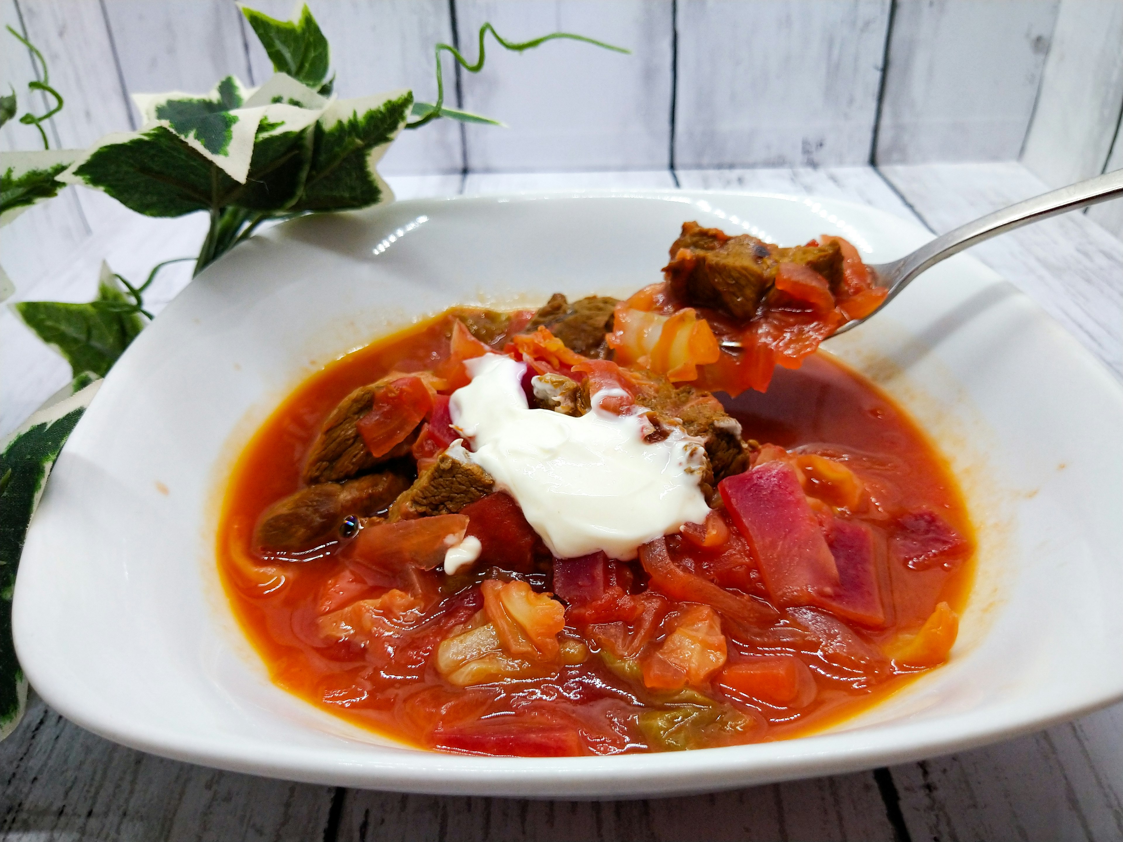 Eine herzhafte Suppe mit Sauerrahm in einer weißen Schüssel