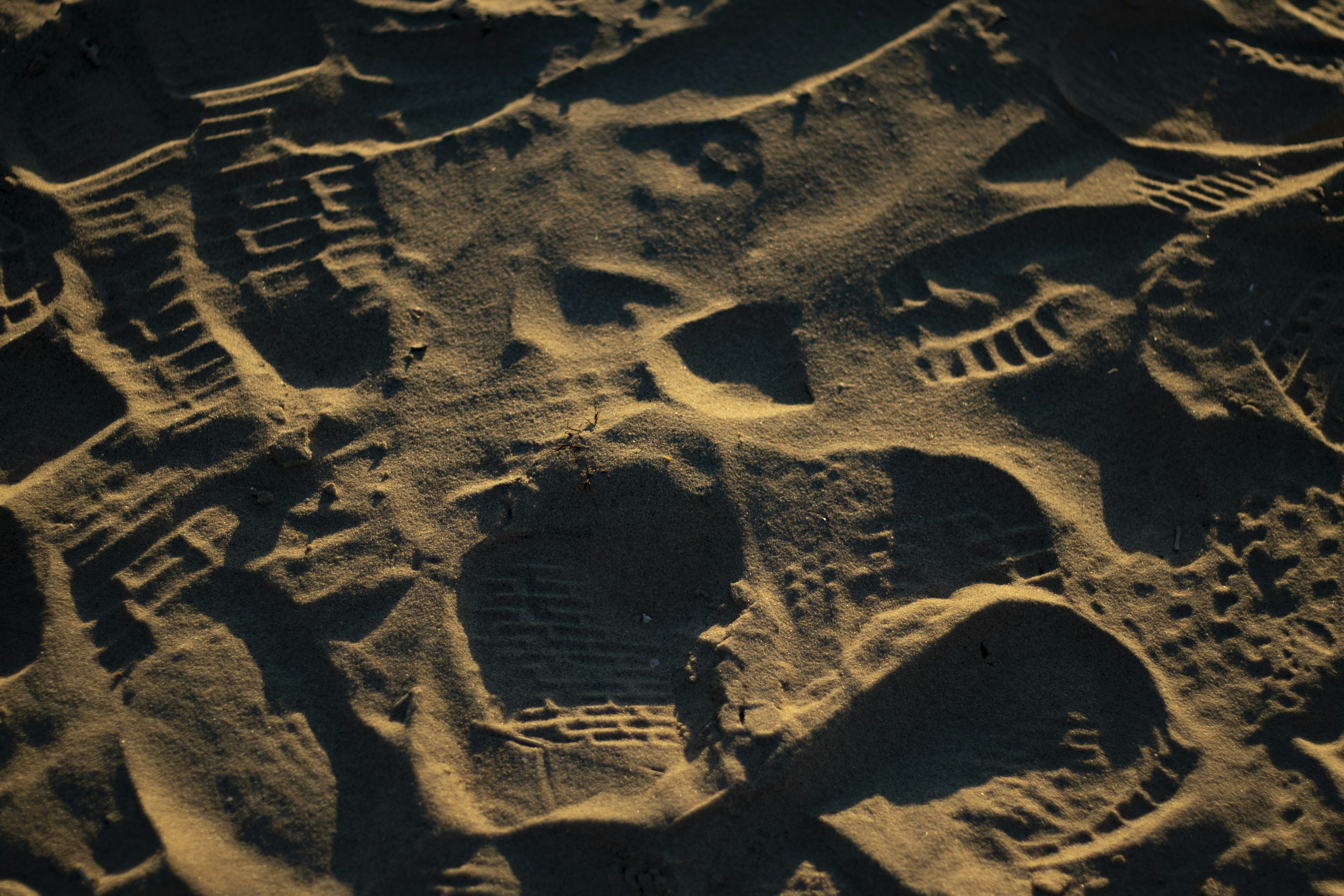 Close-up of footprints and patterns on sandy beach