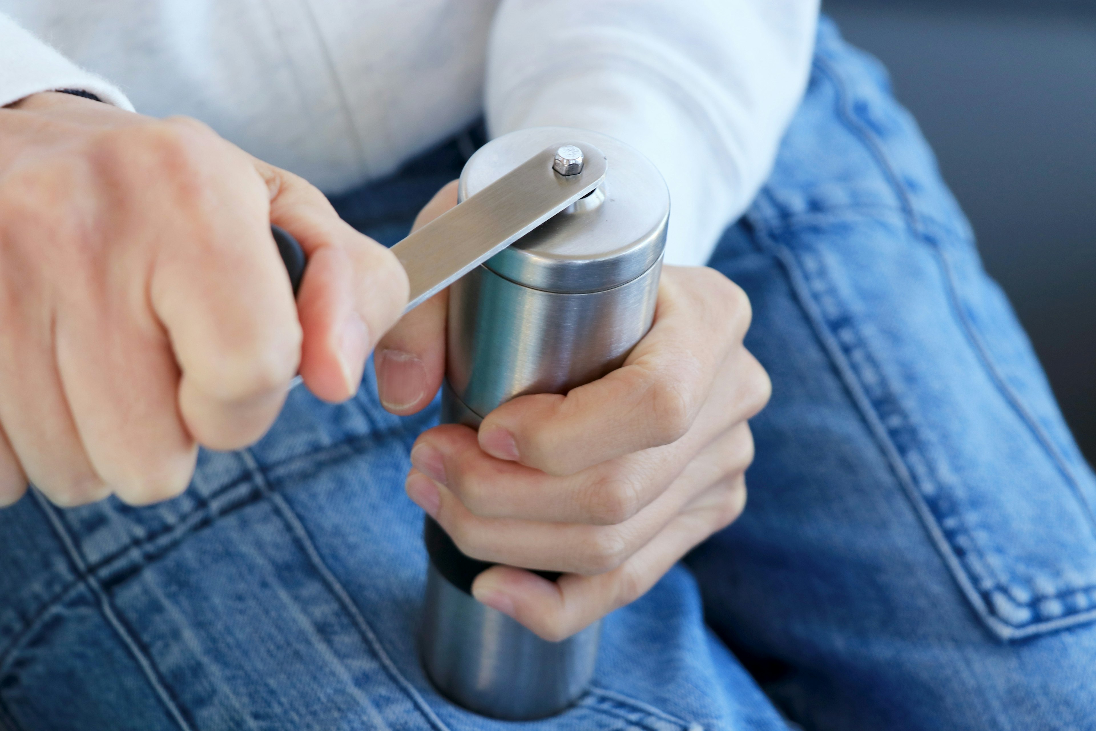 Person using a spice grinder with hands