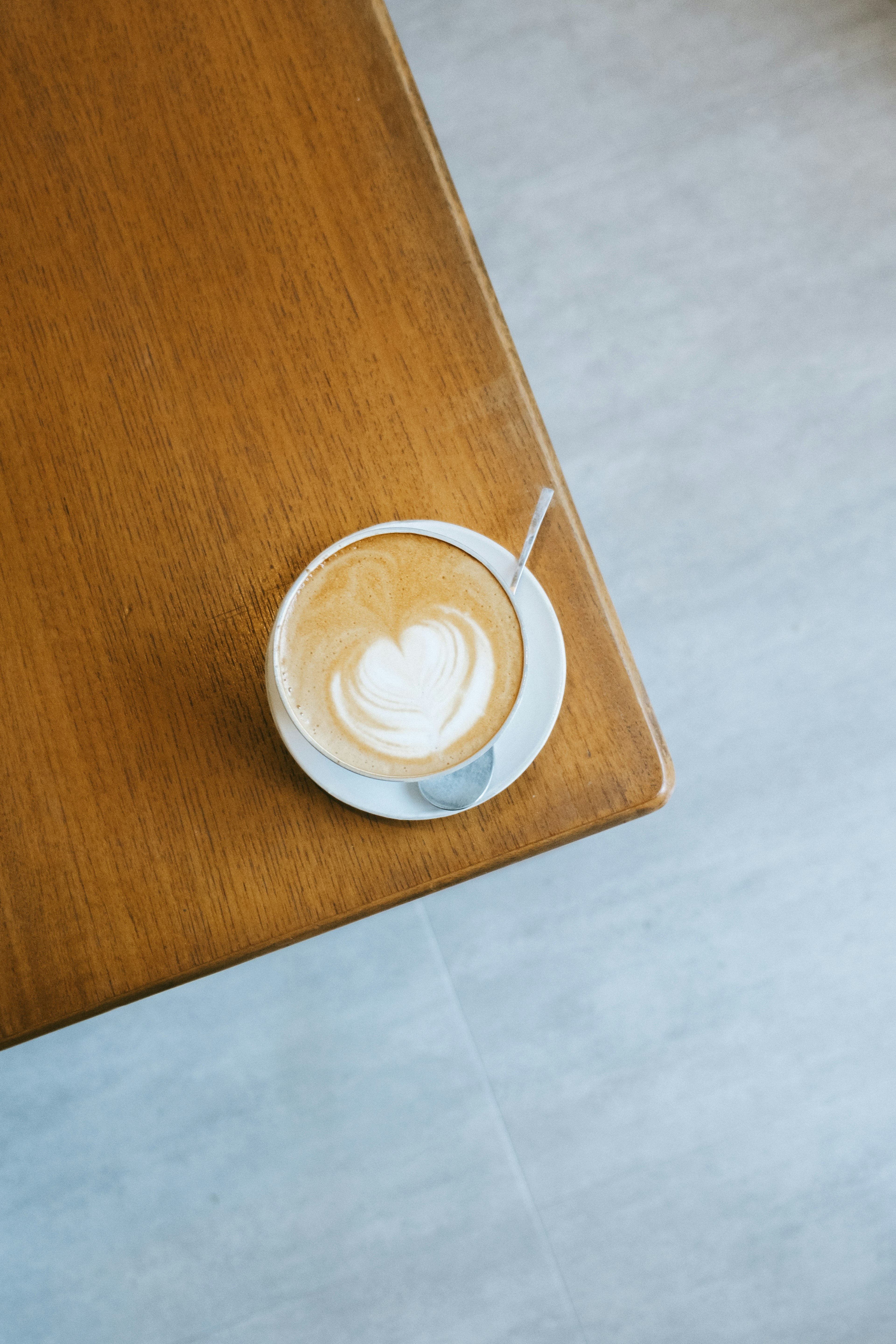 Un café latte avec un motif en forme de cœur sur une table en bois