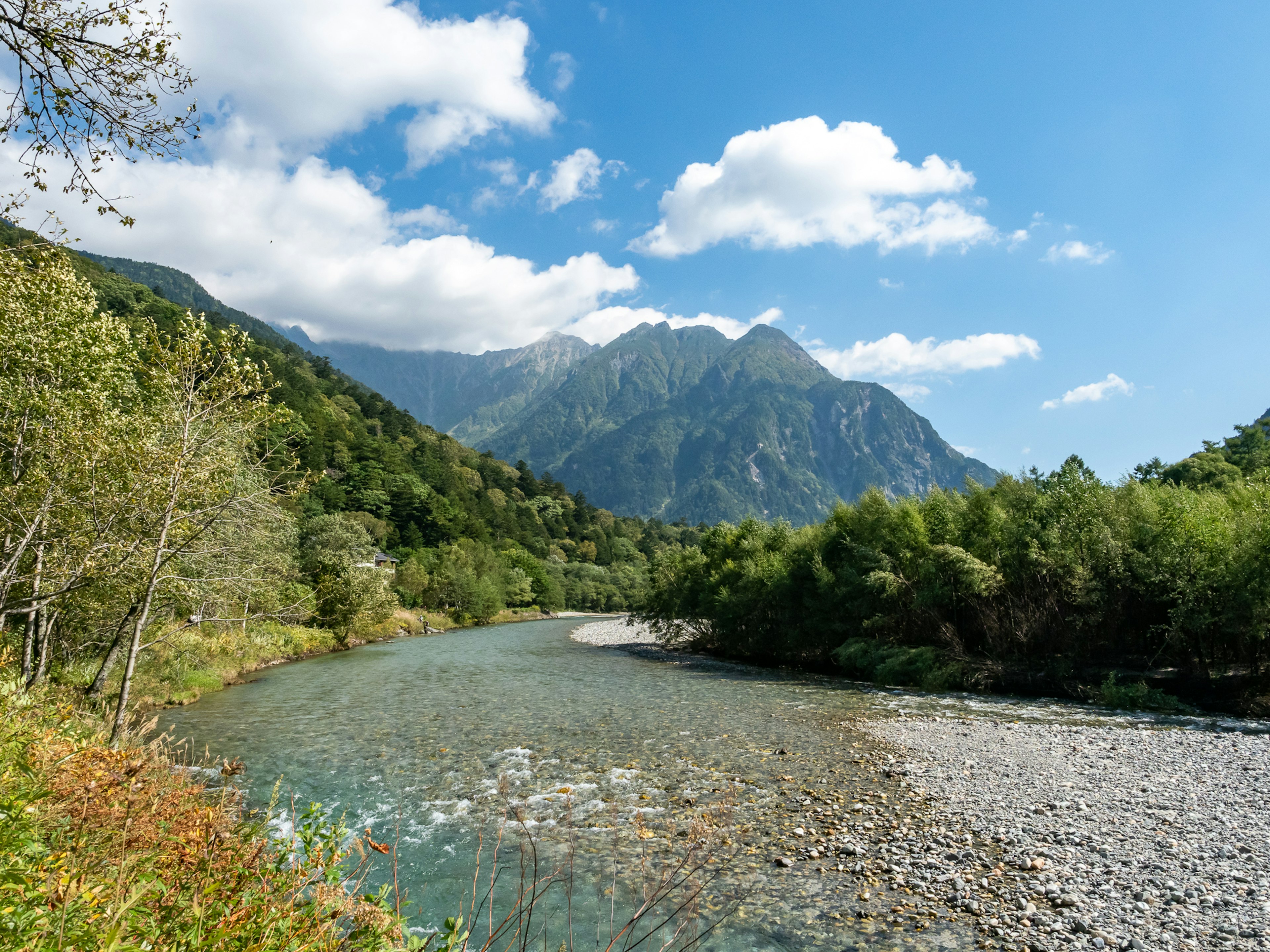 Pemandangan indah sungai tenang dikelilingi pegunungan