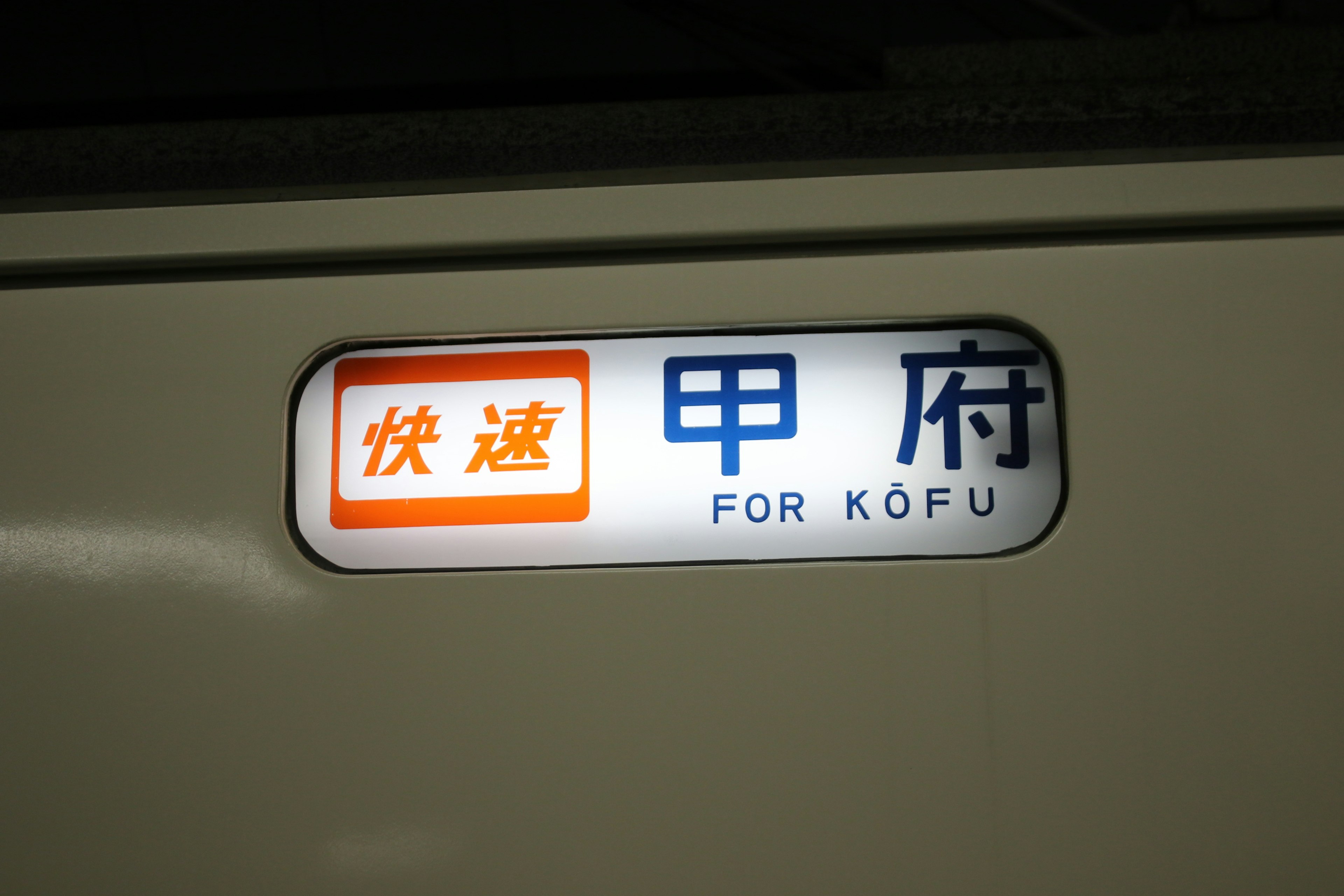 Insegna del treno per Kōfu con colori vivaci e scritte chiare