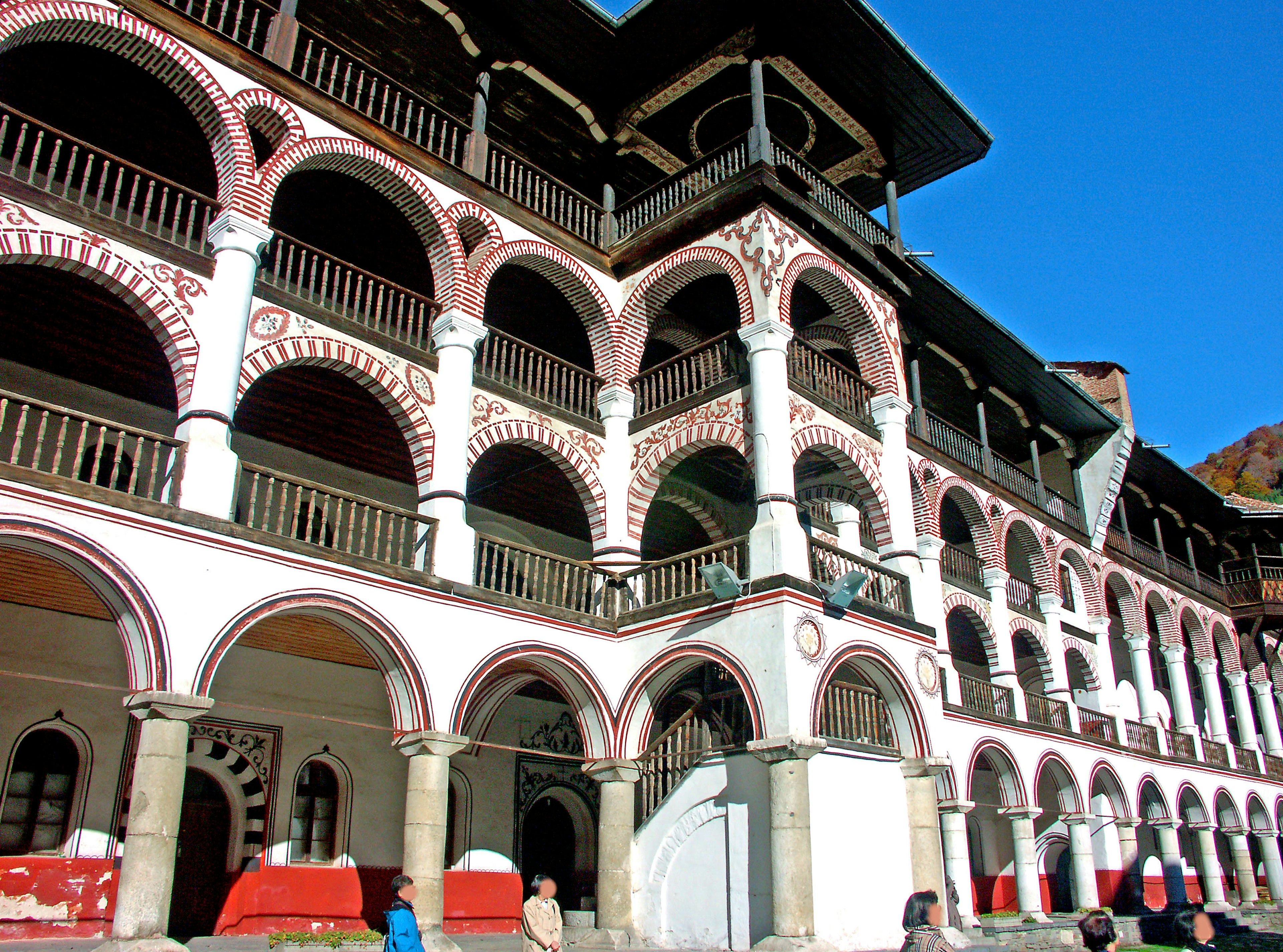 Façade historique d'un monastère avec de belles arches sous un ciel bleu clair