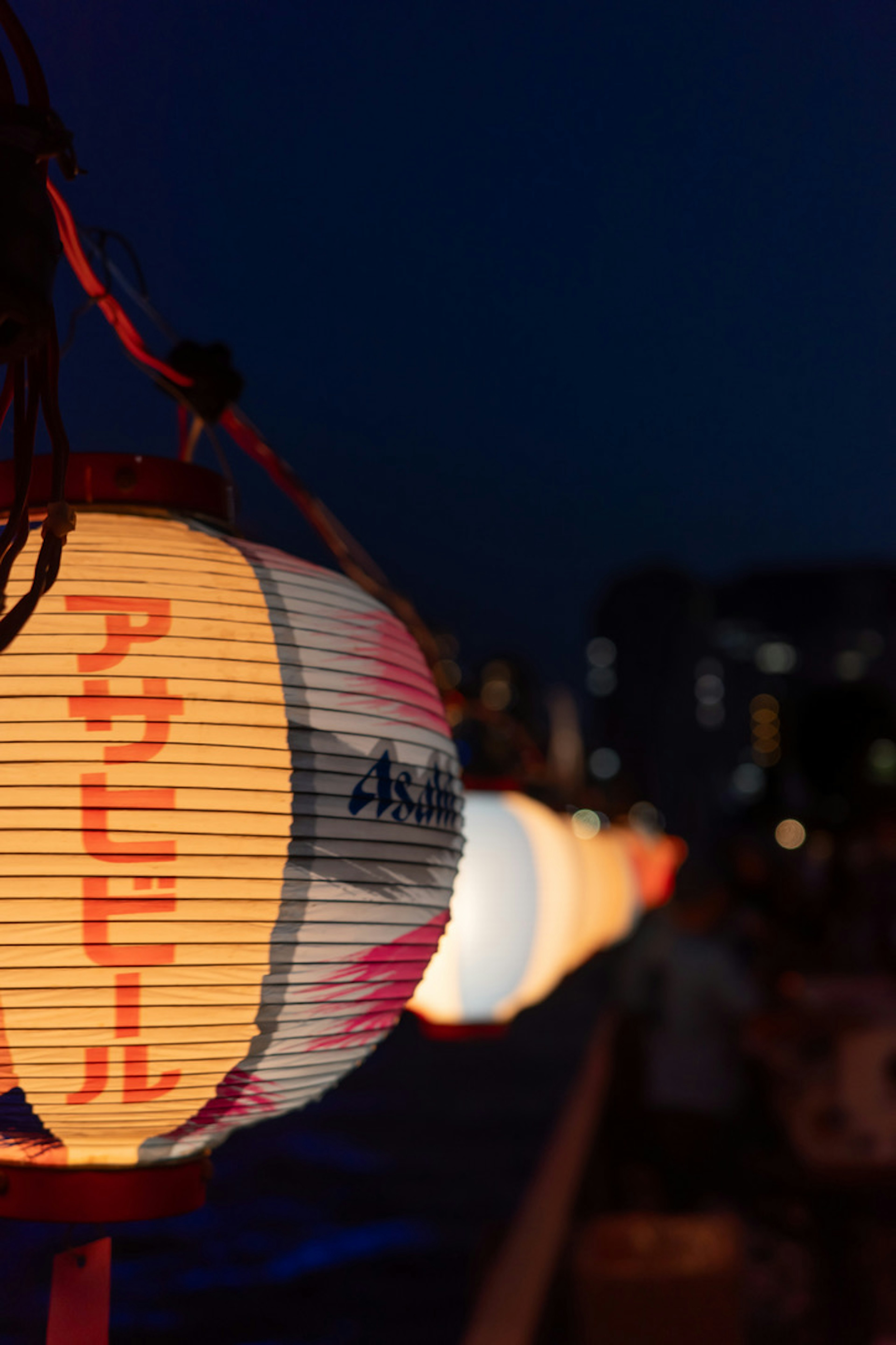 Una fila di lanterne illuminate sotto il cielo notturno con design giapponese tradizionale