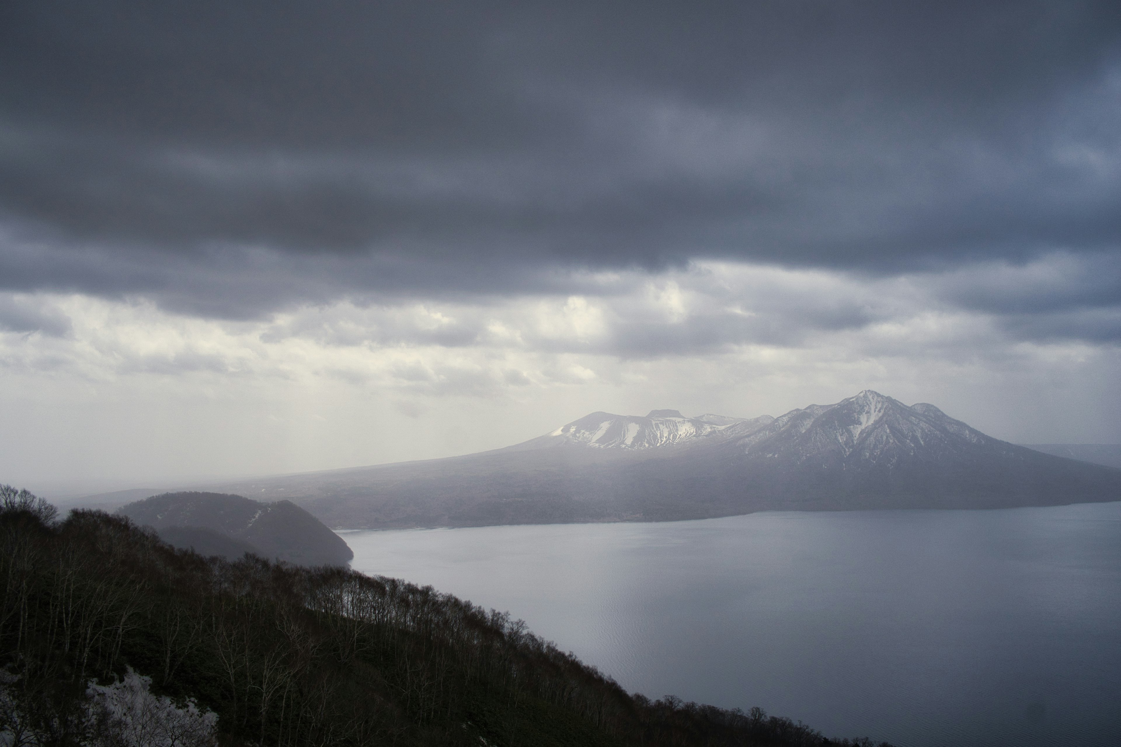 雪をかぶった山々と暗い雲の空の風景