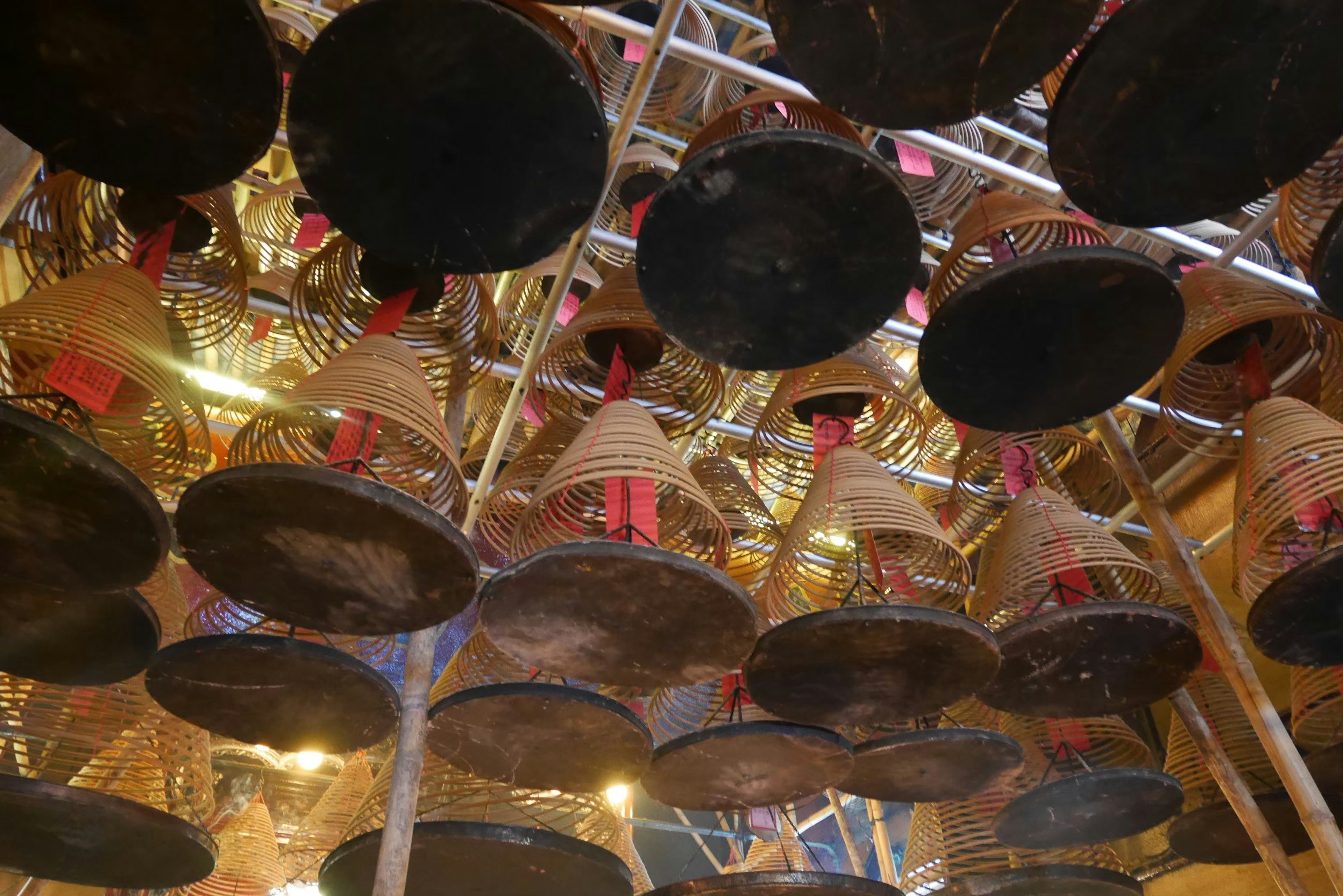 Black bells hanging from the ceiling with golden decorations