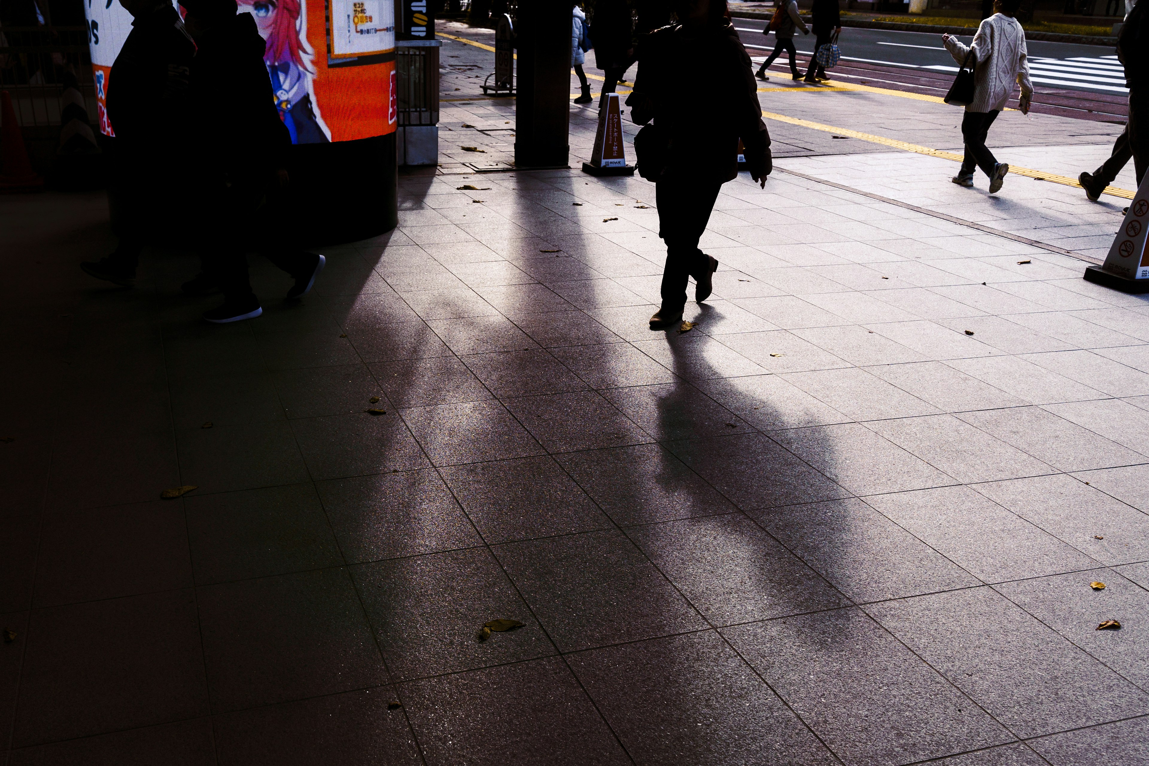 Street scene with shadows of people walking