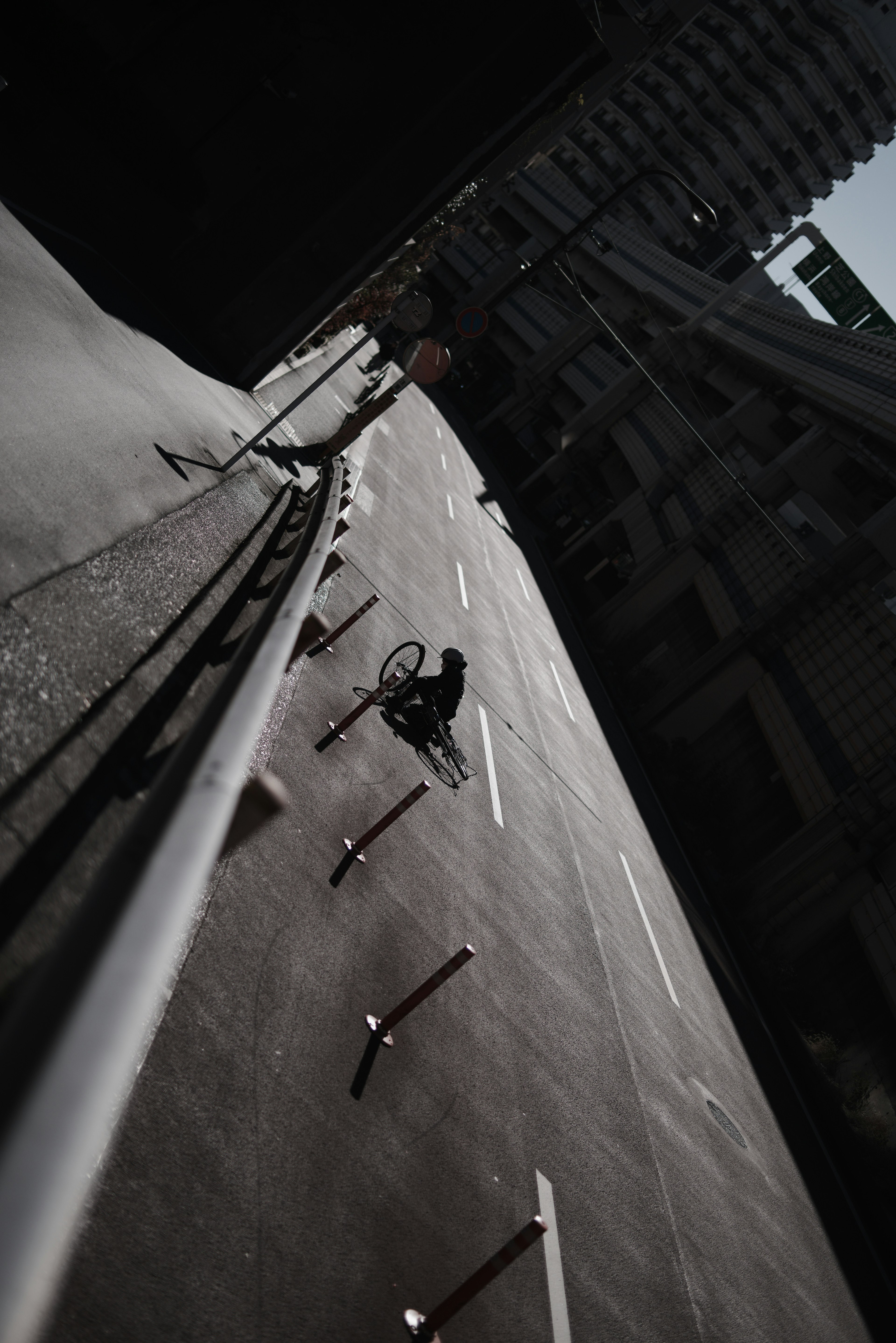 An angled road with a metal railing and urban surroundings