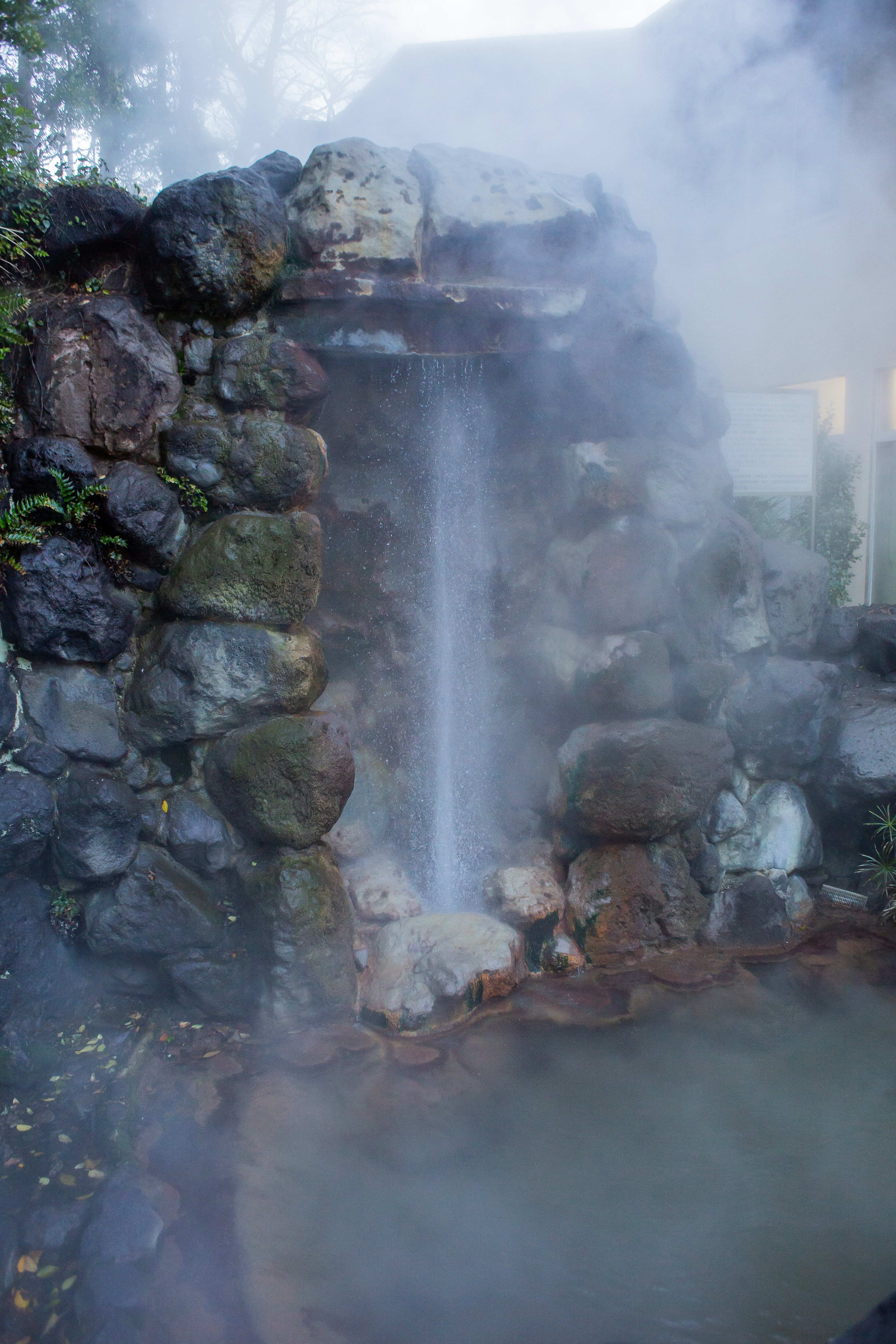 Fonte calda scenica con vapore e cascata di pietra