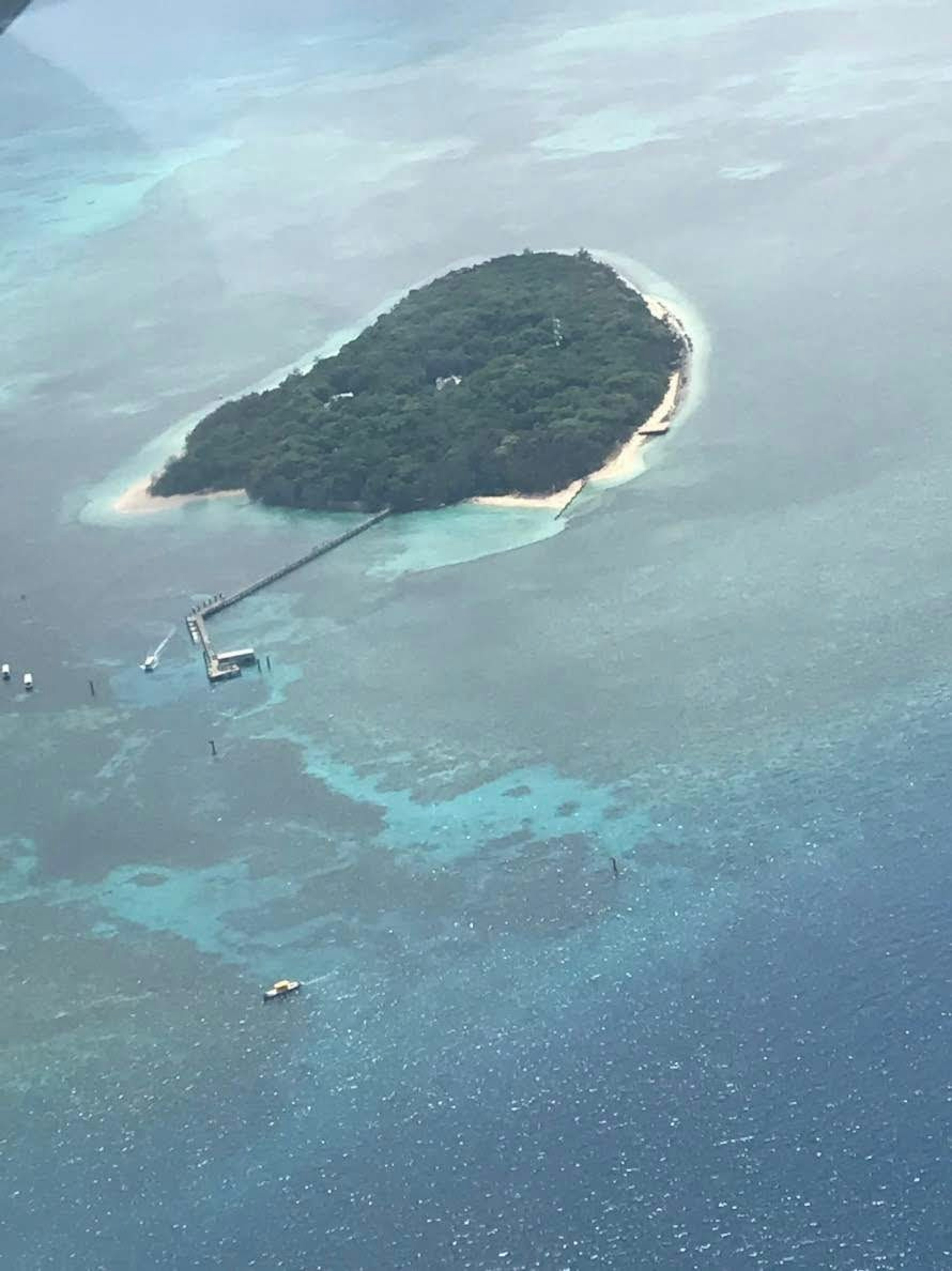 Vista aérea de una isla con forma de corazón rodeada de aguas azules