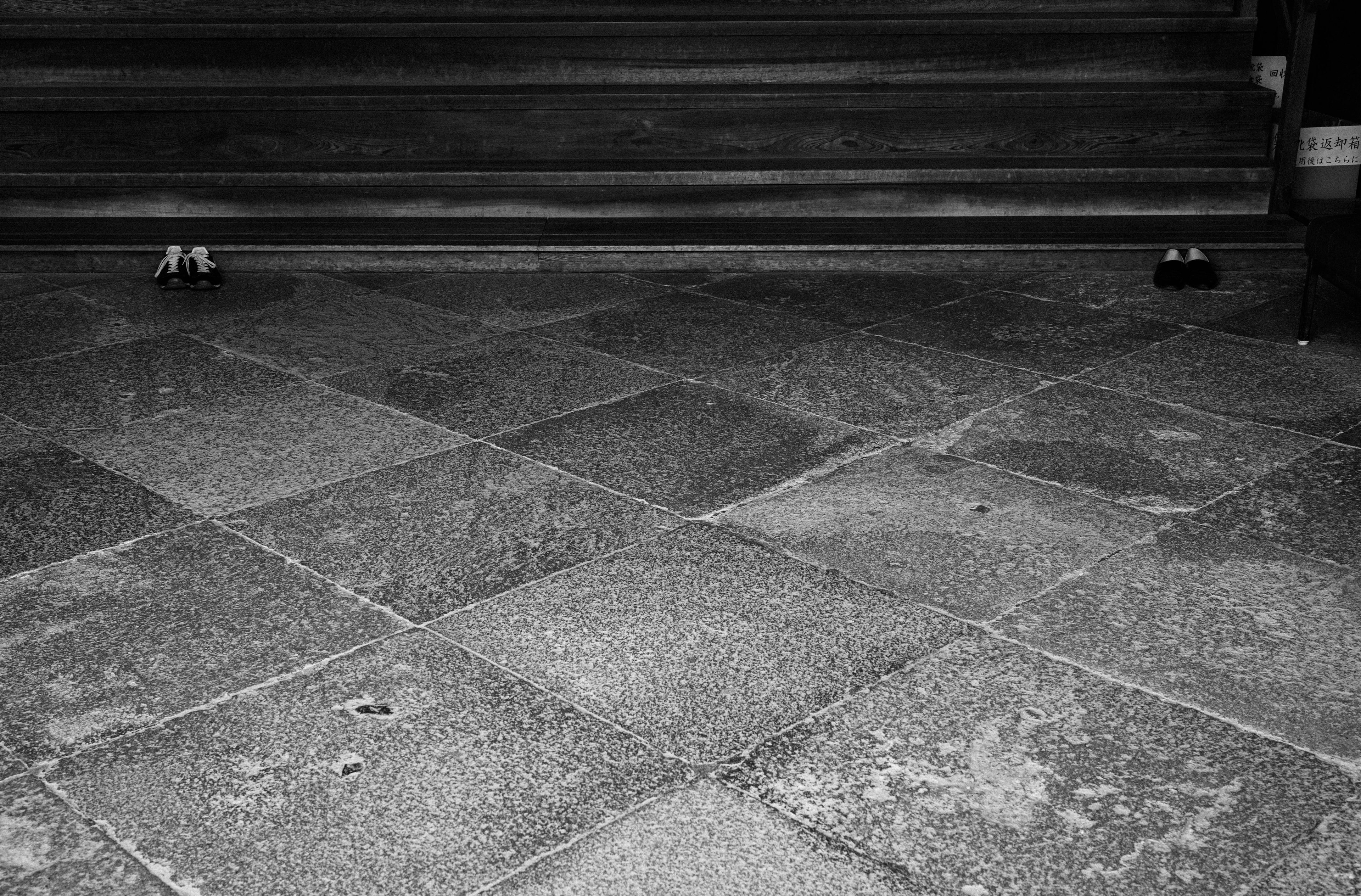 Schwarzweißfoto eines Steinbodens vor einer Treppe