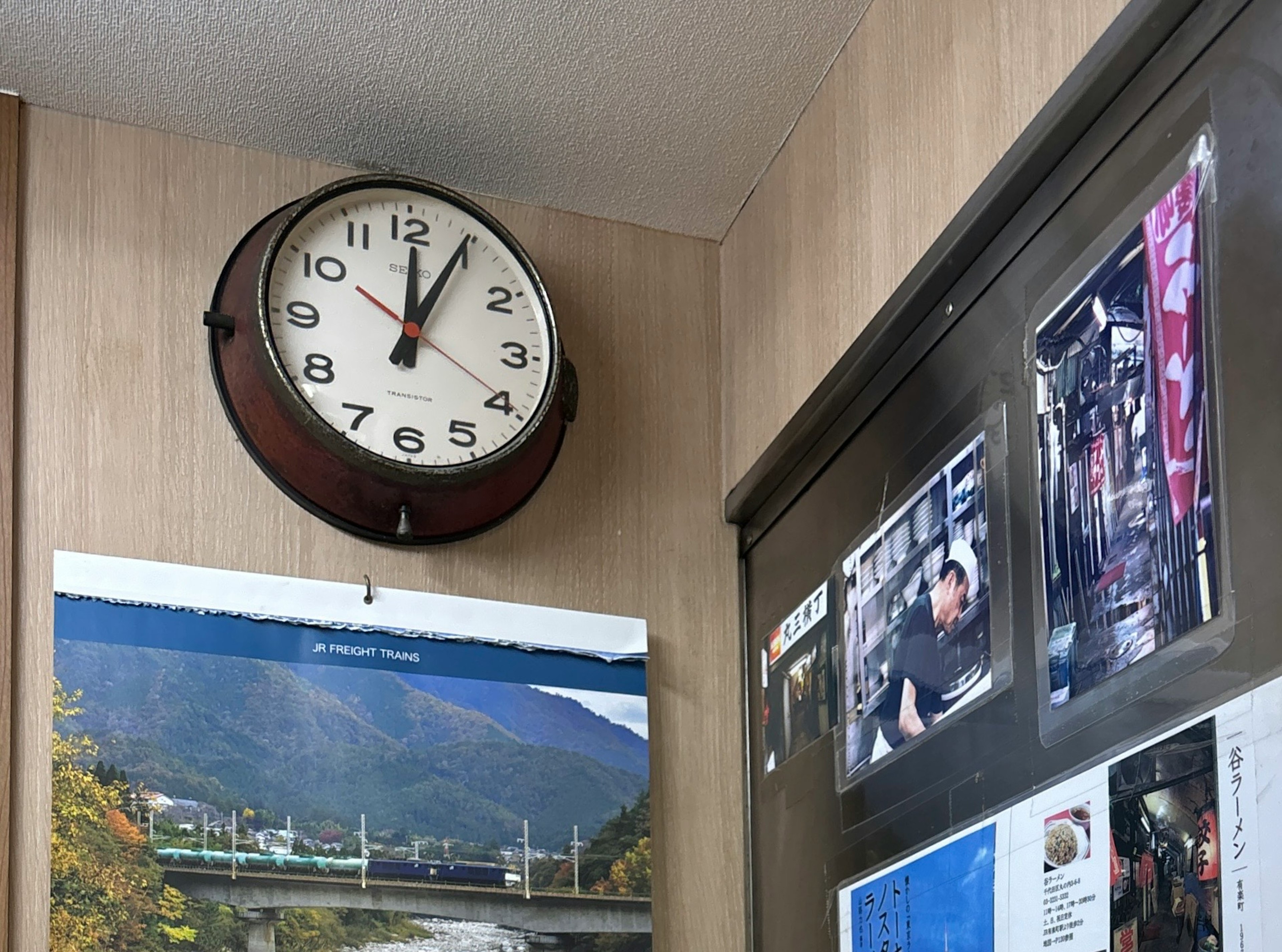 Innenraum mit einer alten Analog-Uhr und einem Landschaftsbild an der Wand