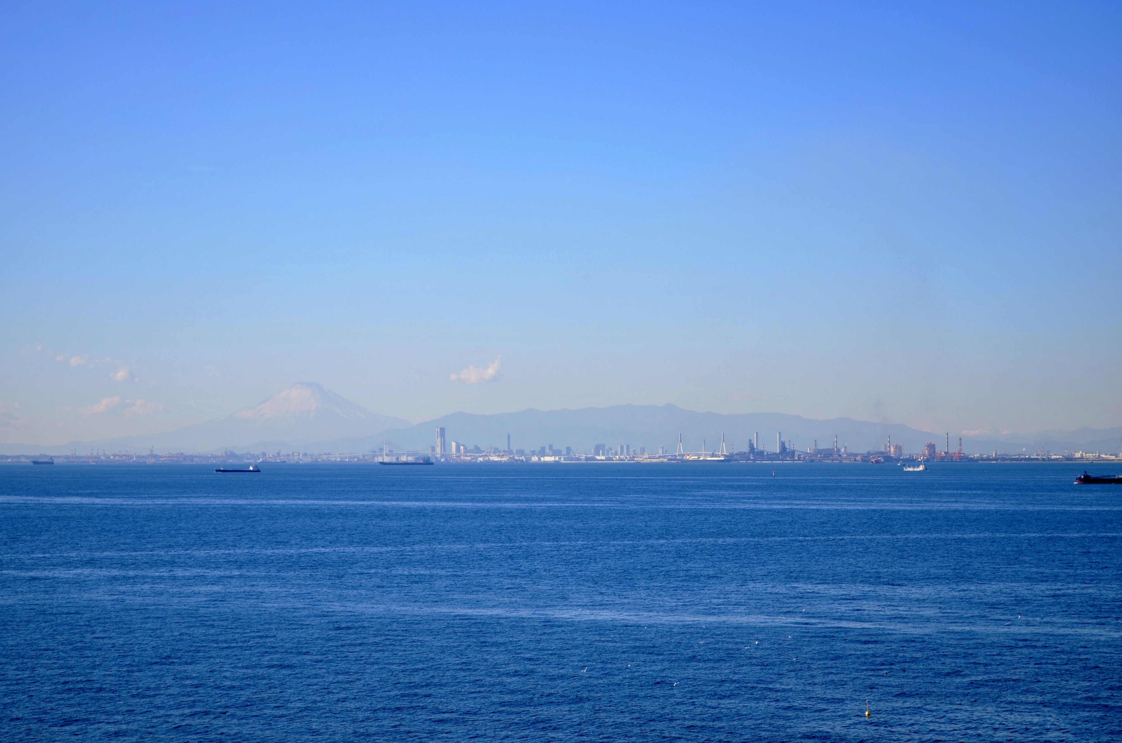 City skyline silhouette against a blue sky and sea