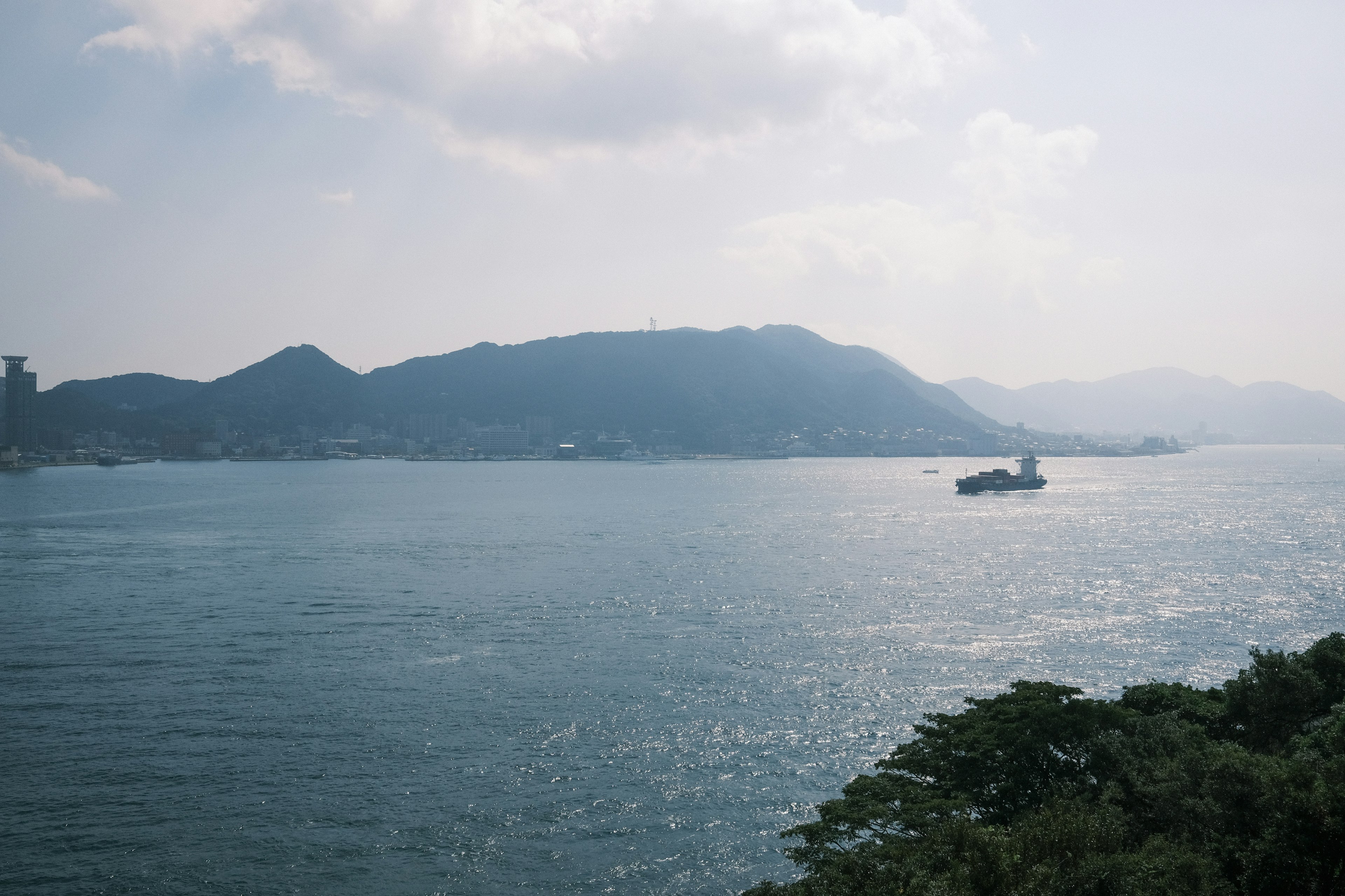 Surface d'eau calme avec un paysage montagneux un bateau naviguant