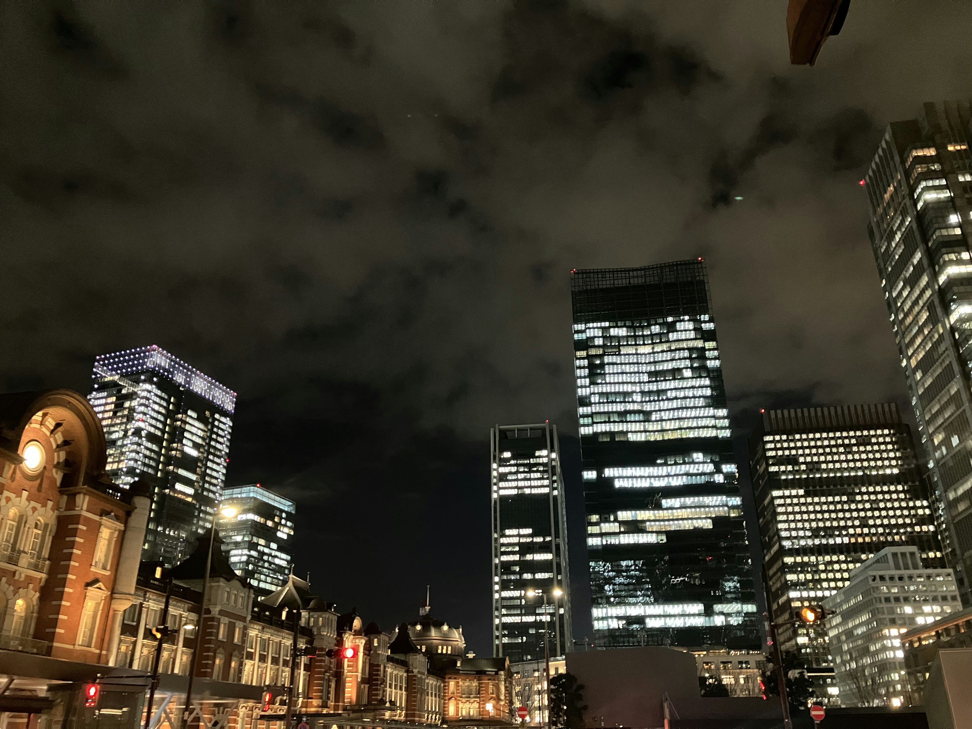 Pemandangan kota malam hari dengan gedung pencakar langit dan langit berawan